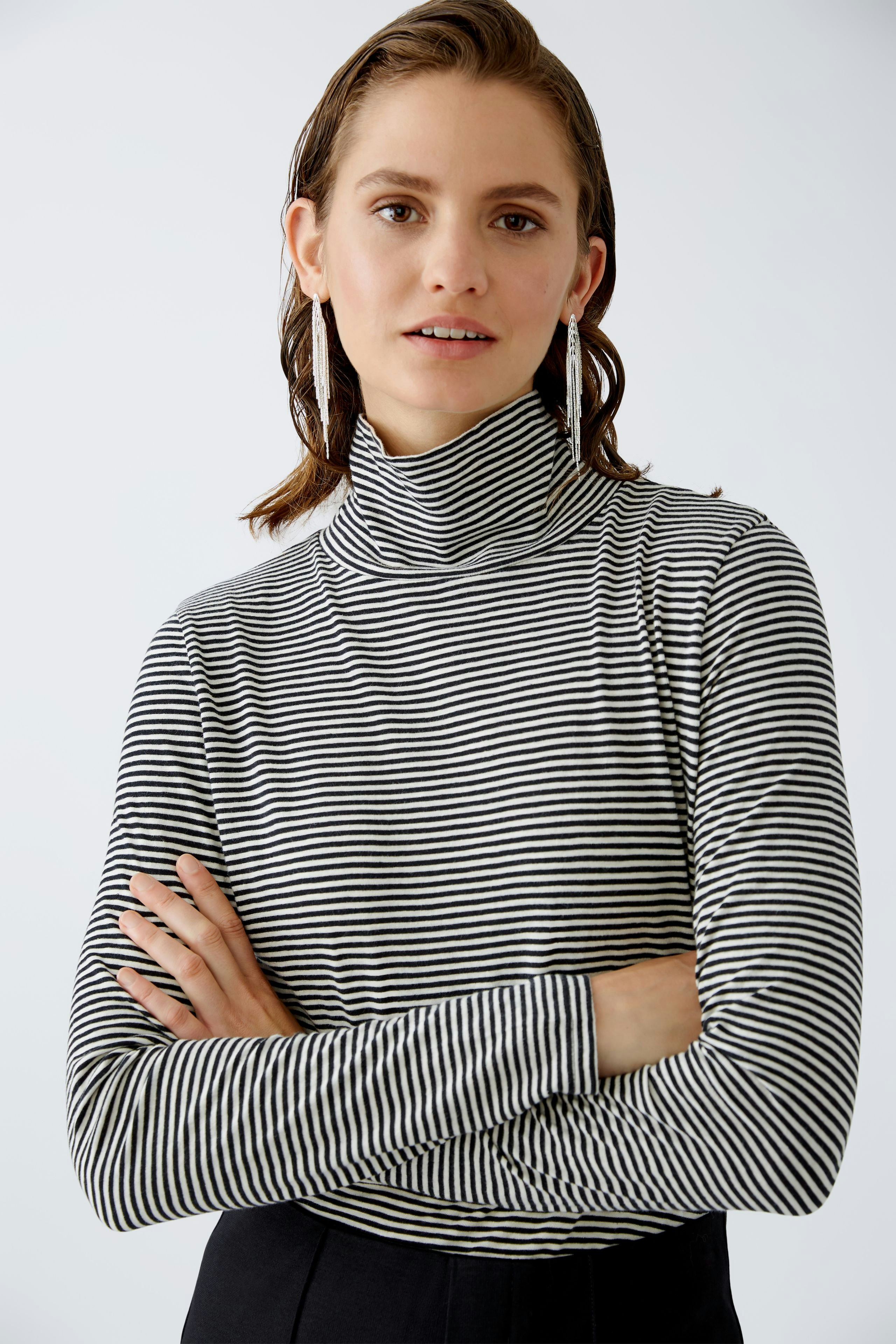 Damen-Pullover: Frau in gestreiftem Rollkragenpullover mit lässigem Look.