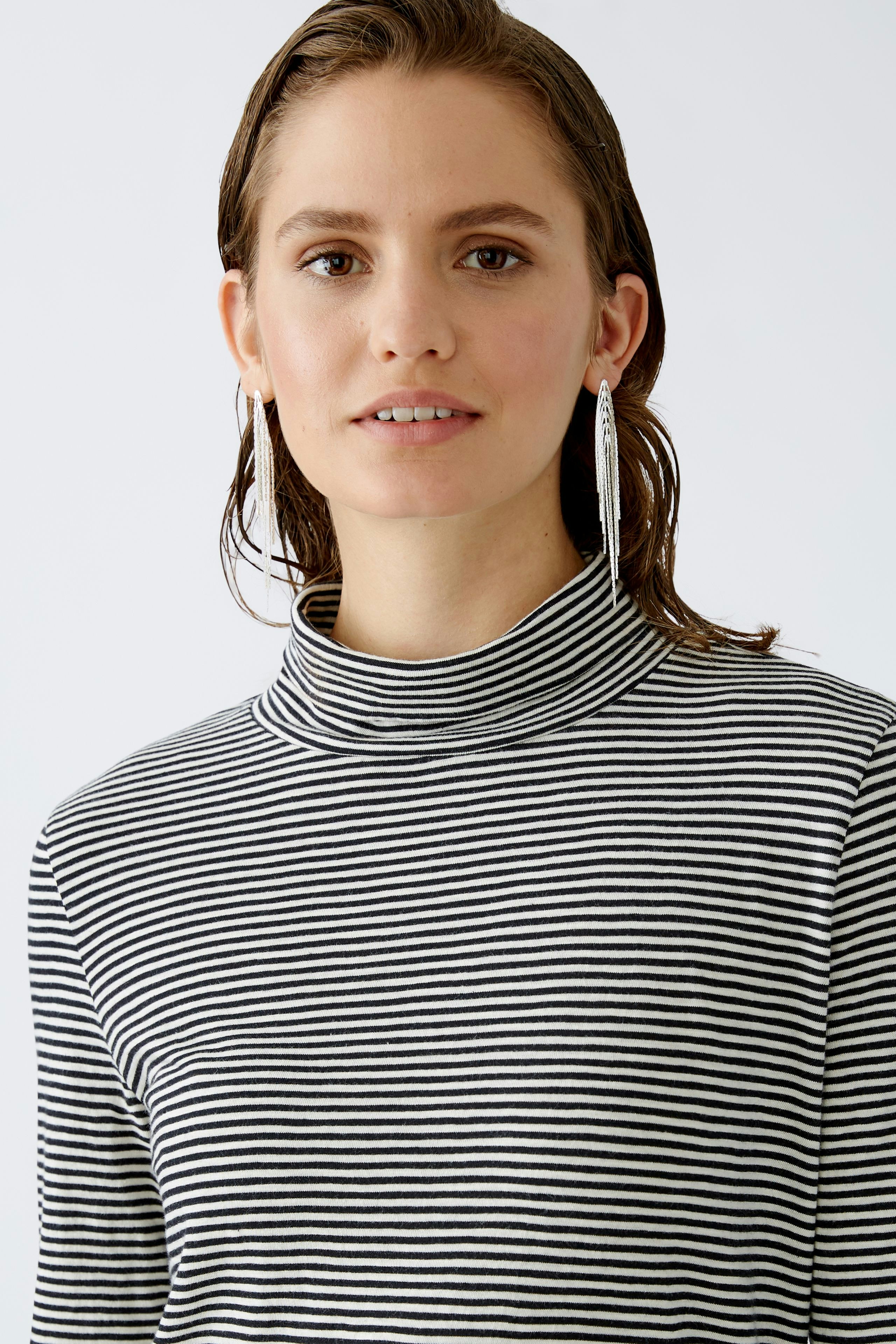 Damen-Pullover: Frau in gestreiftem Rollkragenpullover mit lässigem Look.