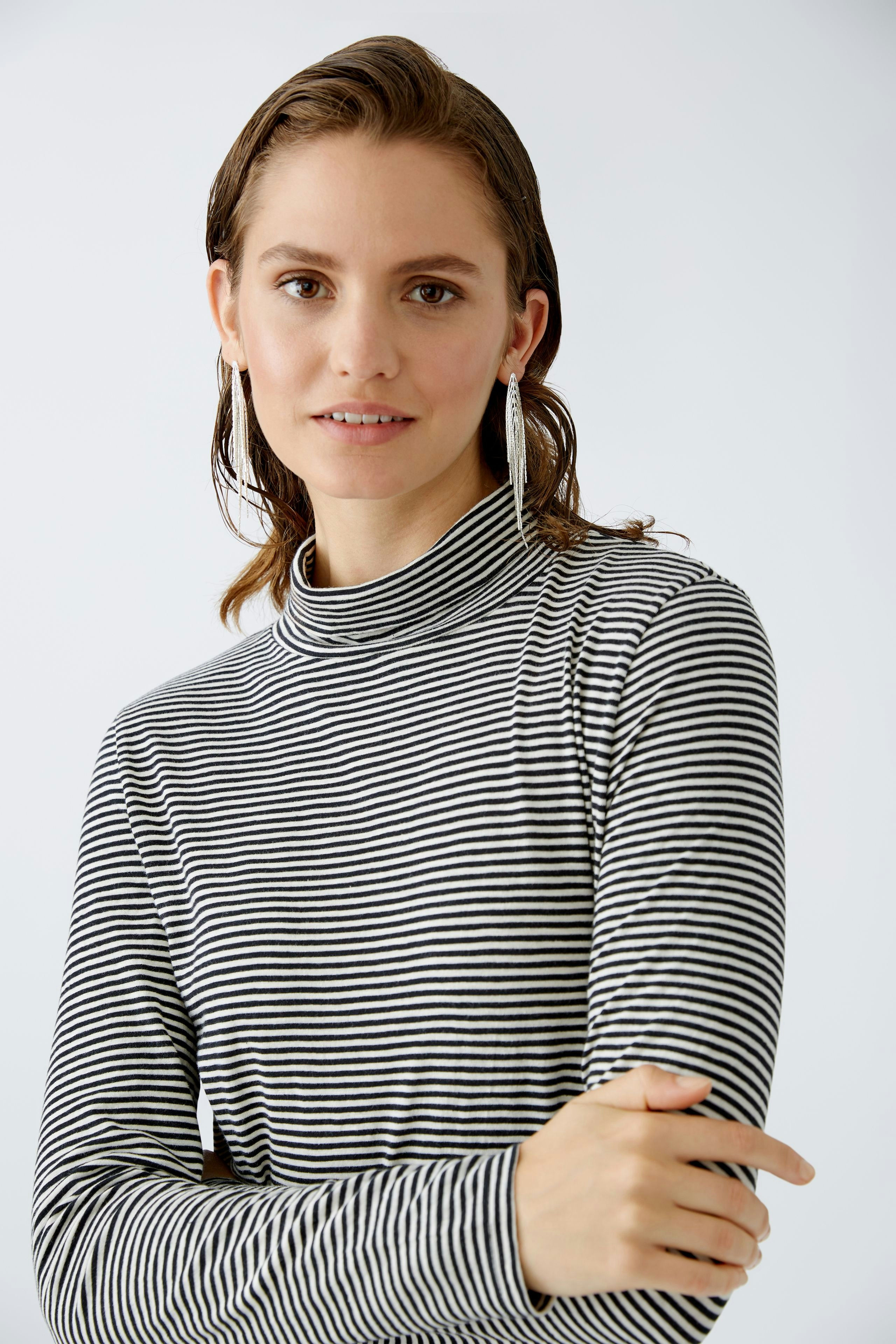 Streifenpullover: Junge Frau in gestreiftem Rollkragenpullover mit lässigem Look.