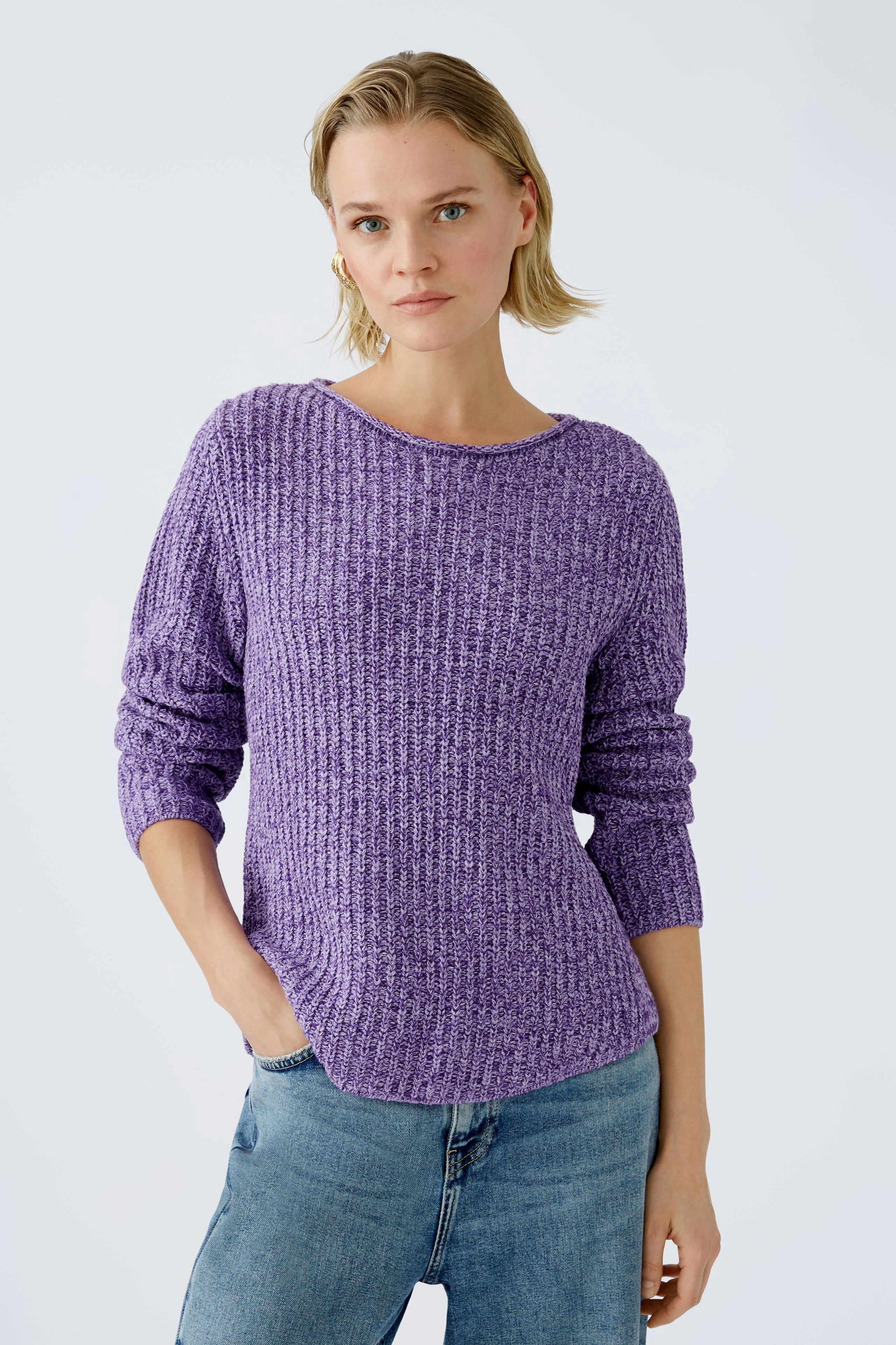 Modern women's pullover: A woman in a textured purple pullover paired with casual jeans.