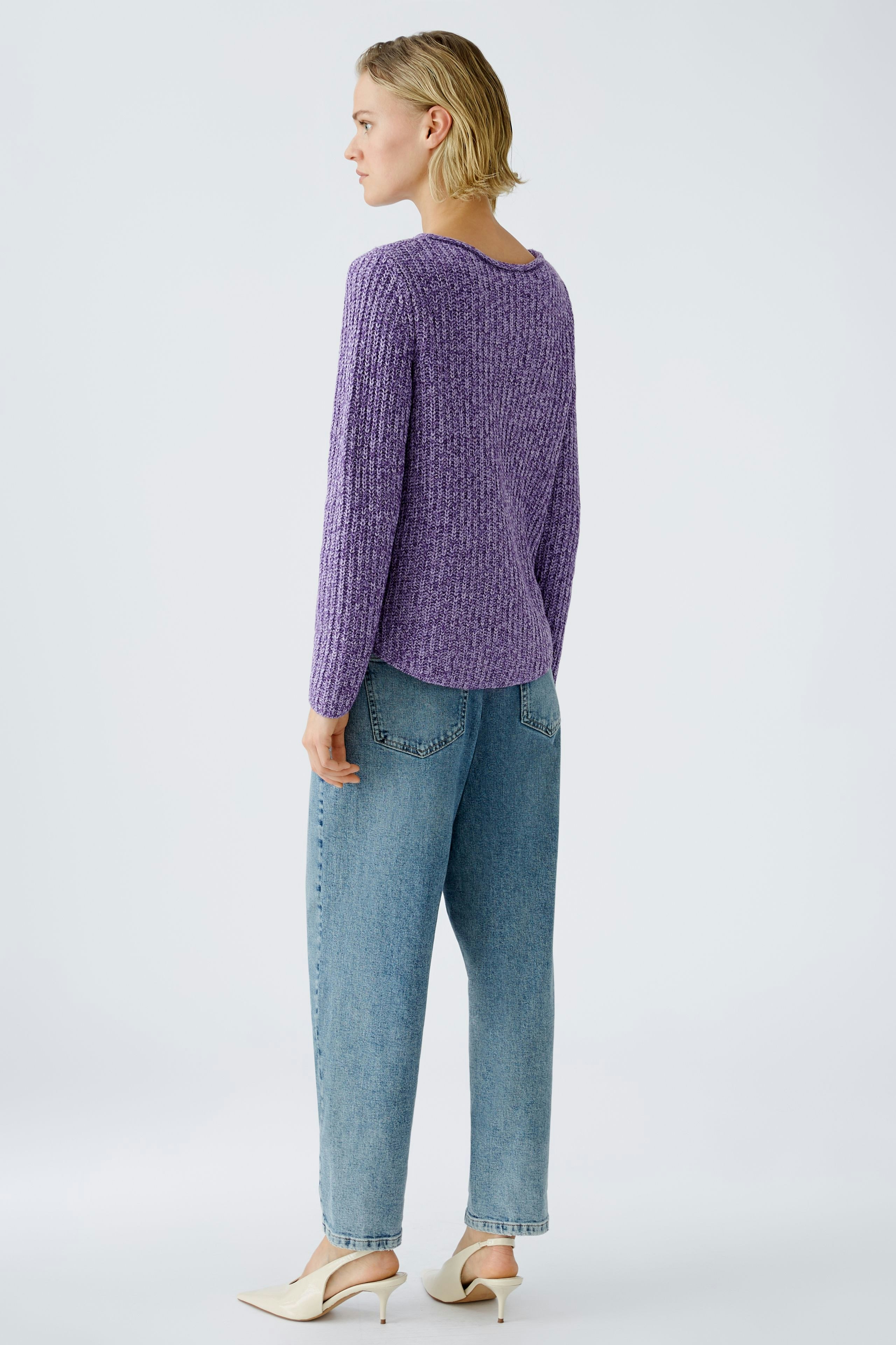 Damen-Pullover: Frau in lila Strickpullover mit lässigem Schnitt und Jeans, von hinten betrachtet.