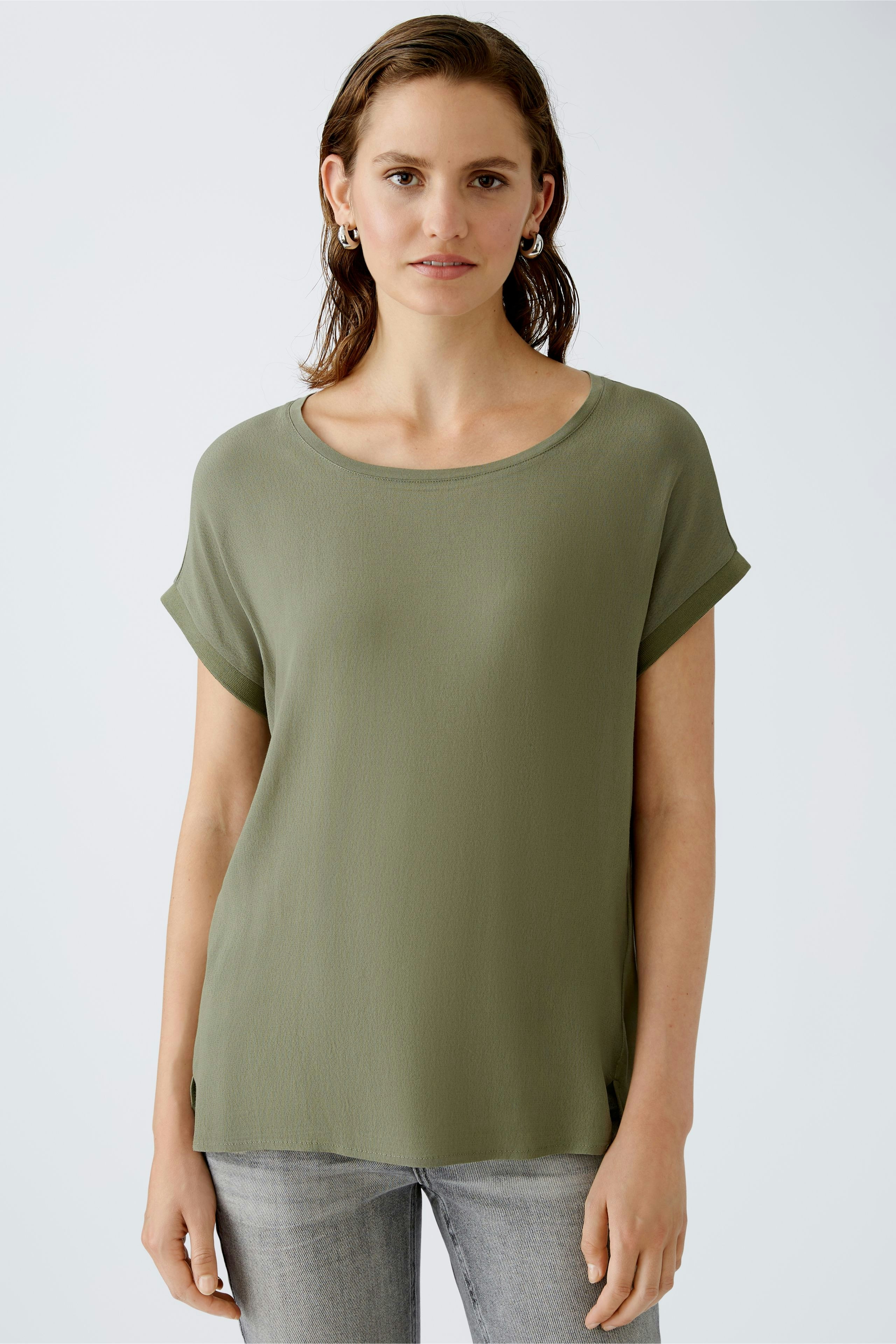 Casual women's blouse shirt in olive green, featuring rolled sleeves and a relaxed fit.