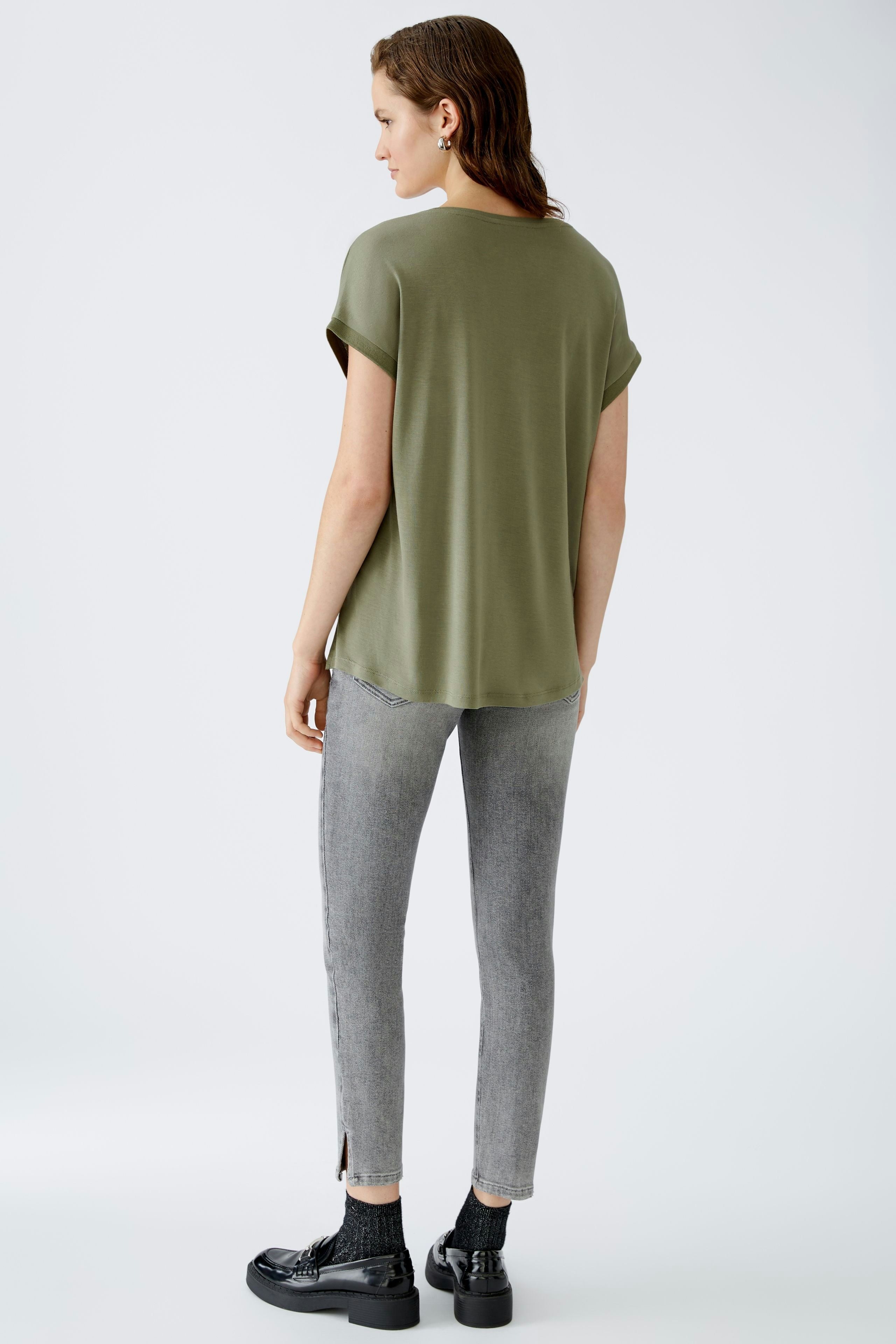 Casual women's blouse shirt in olive green, featuring rolled sleeves and a relaxed fit.