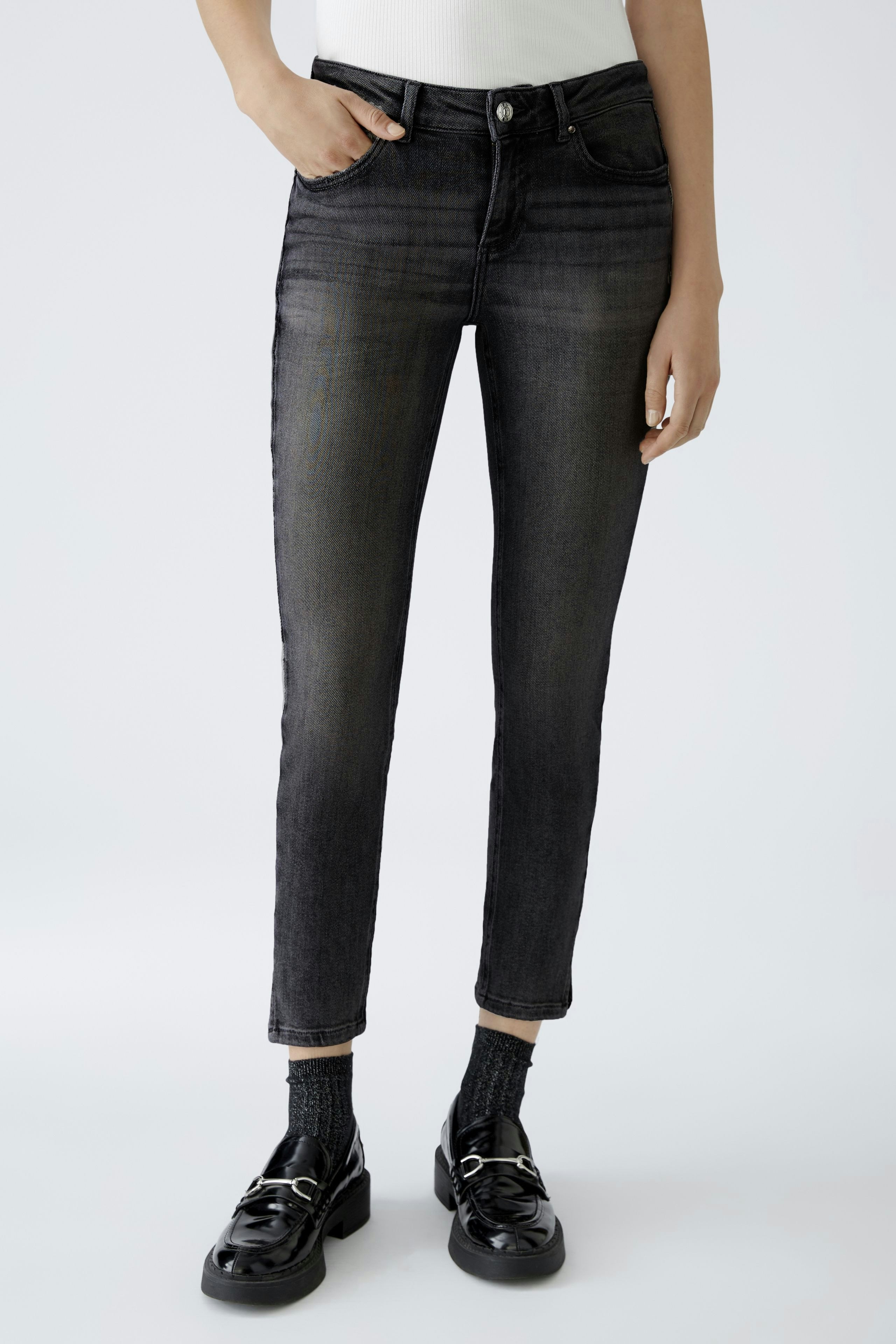 Stylish skinny jeans for women: A woman in dark skinny jeans paired with black shoes.