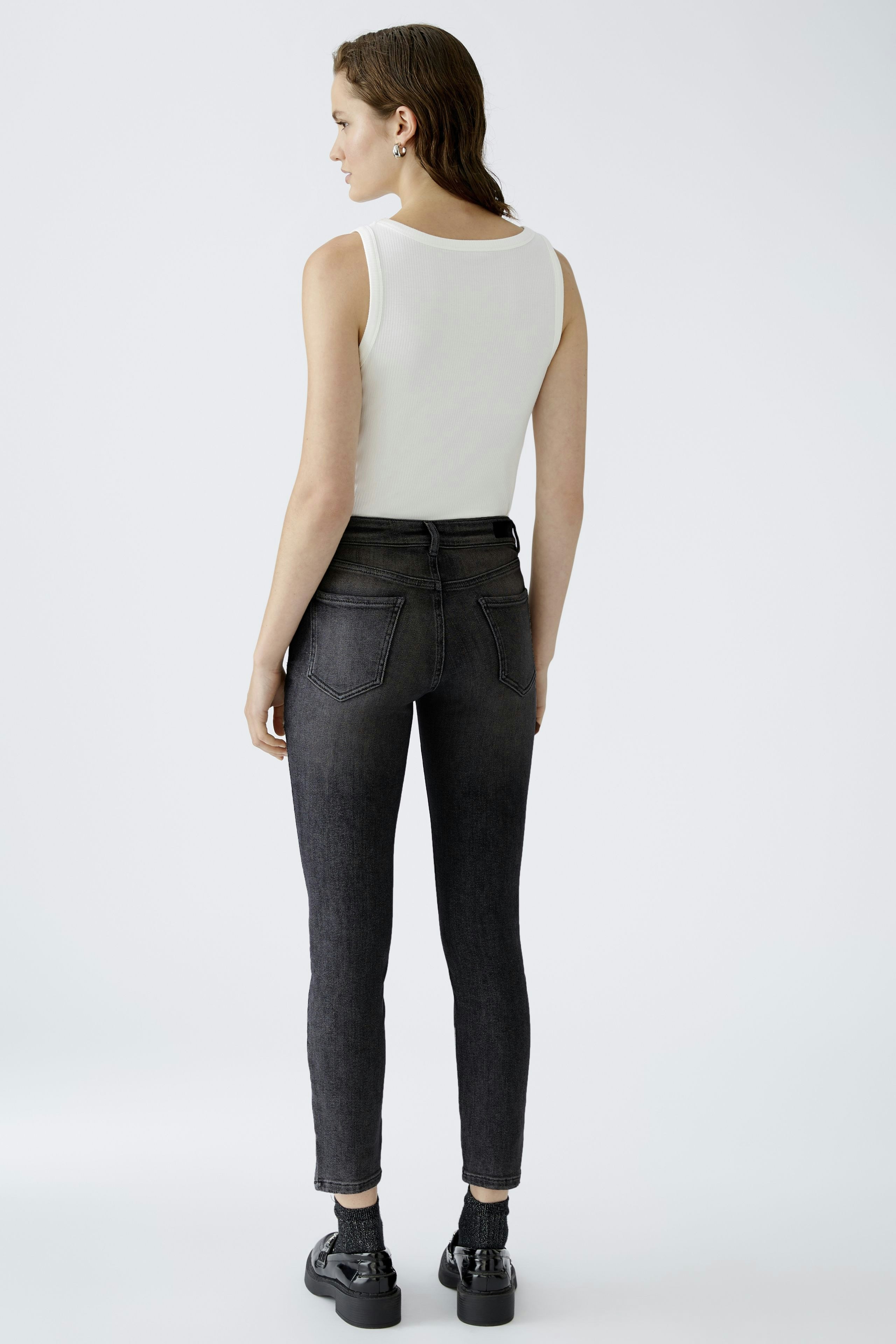 Skinny jeans: Woman in fitted black jeans, showcasing a sleek silhouette and modern style.