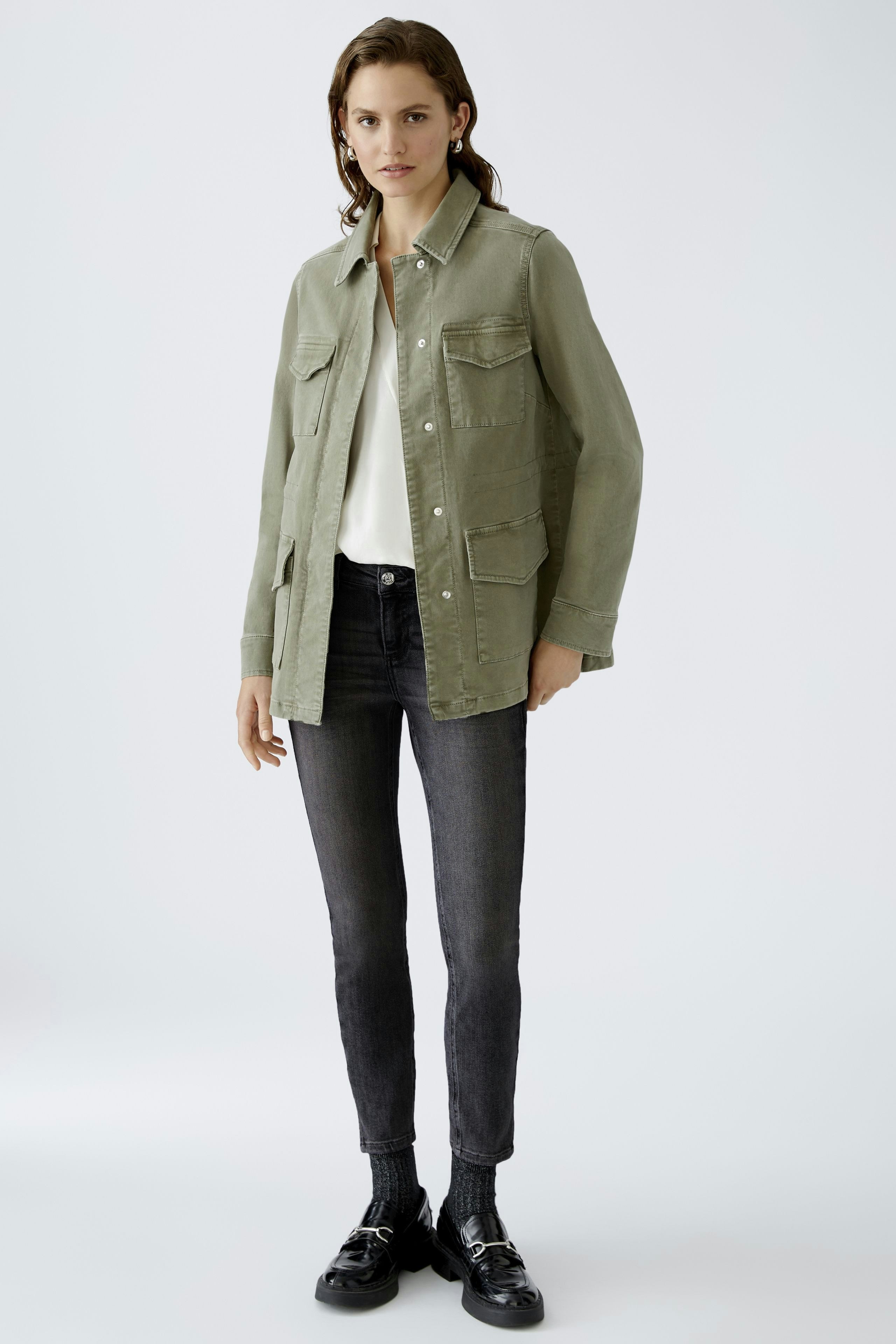 Stylish skinny jeans: A woman in dark skinny jeans paired with a light top and casual jacket.