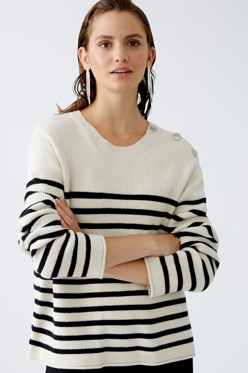 Damen-Pullover: Frau in gestreiftem Pullover mit Knöpfen, lässig und modern.