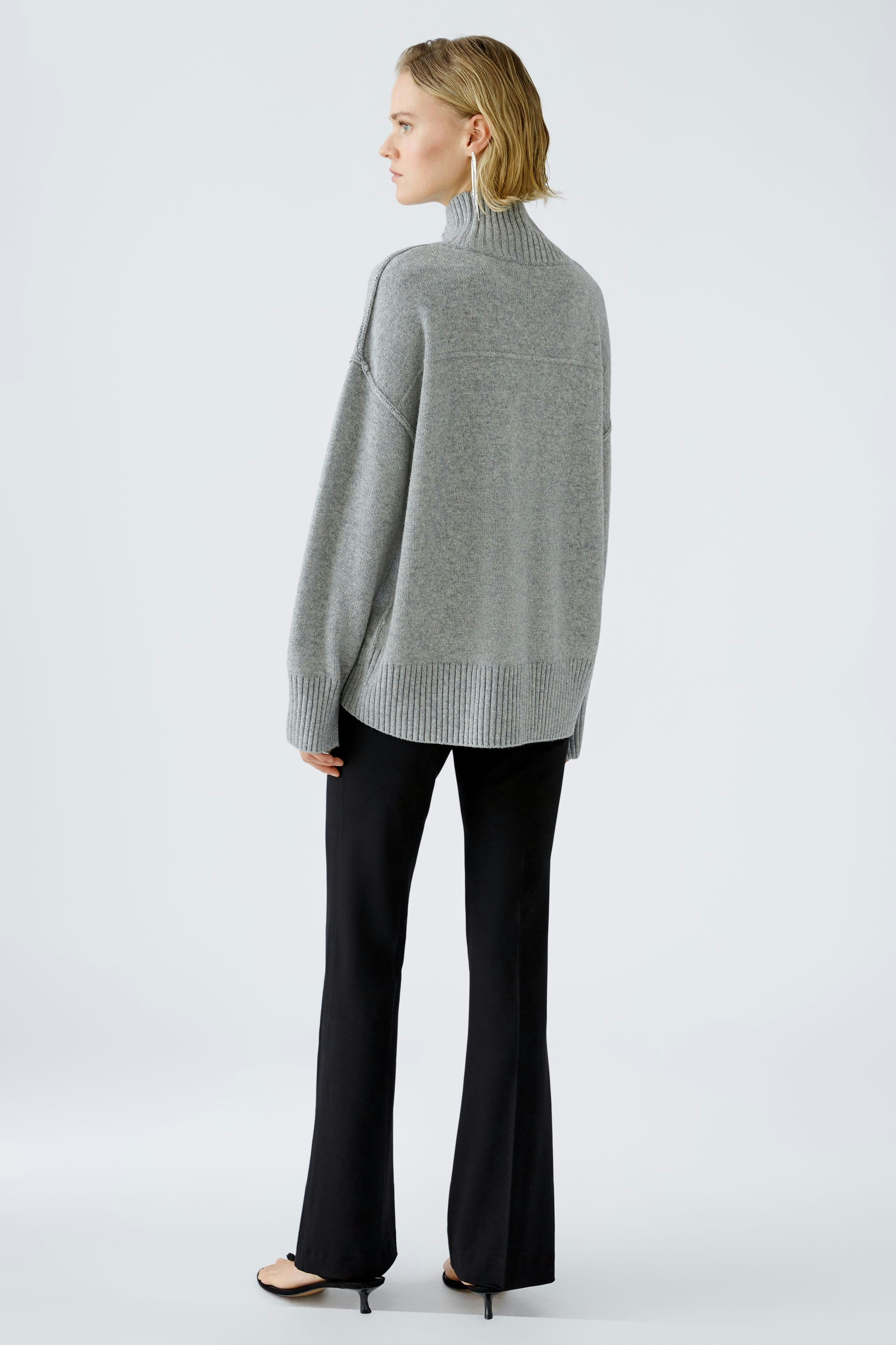 Stylish women's pullover: A woman in a cozy gray pullover with a relaxed fit, showcasing effortless elegance.