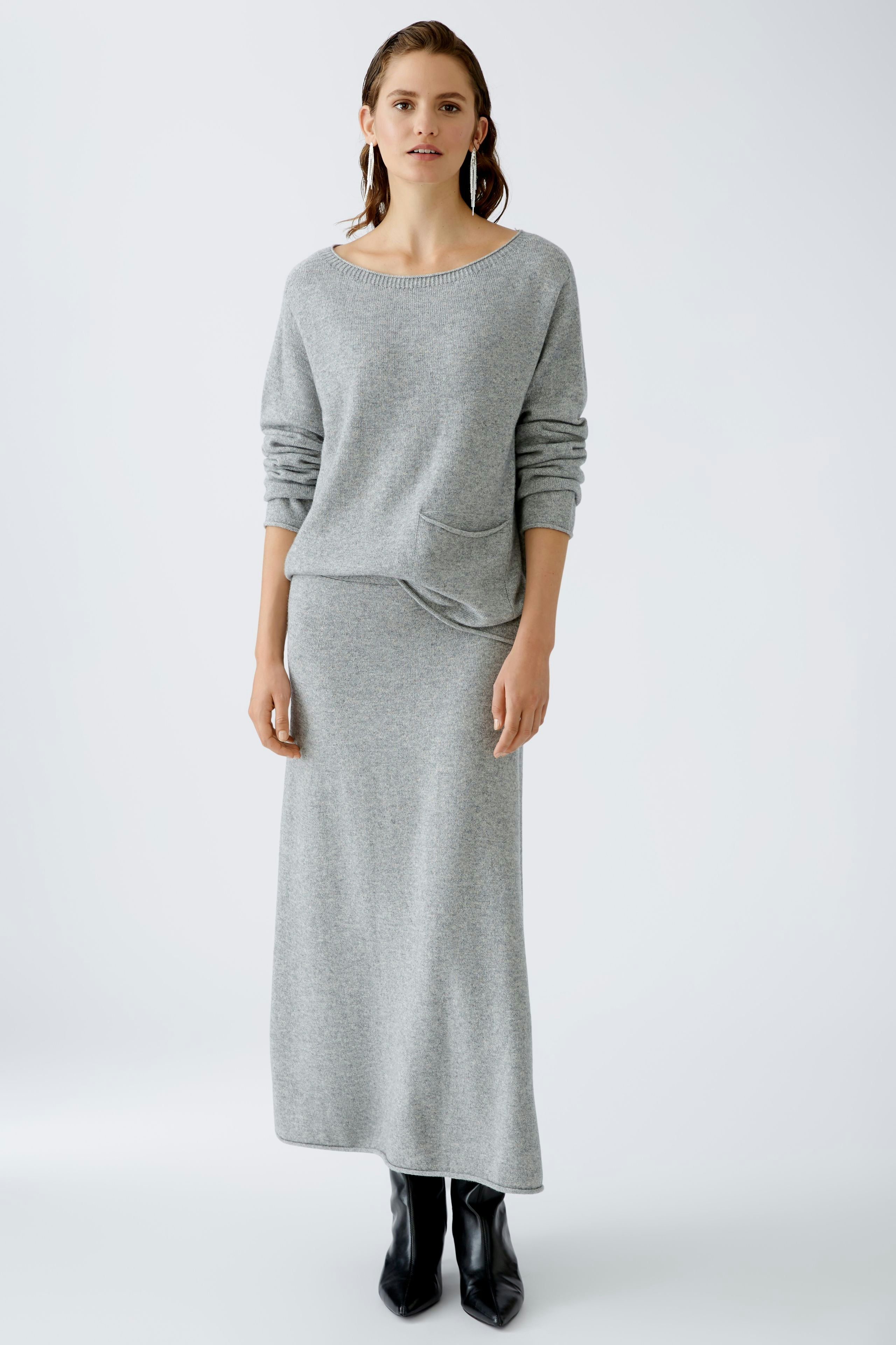 Eleganter Damen-Pullover: Frau in grauem, lässigem Strickpullover mit praktischer Tasche.