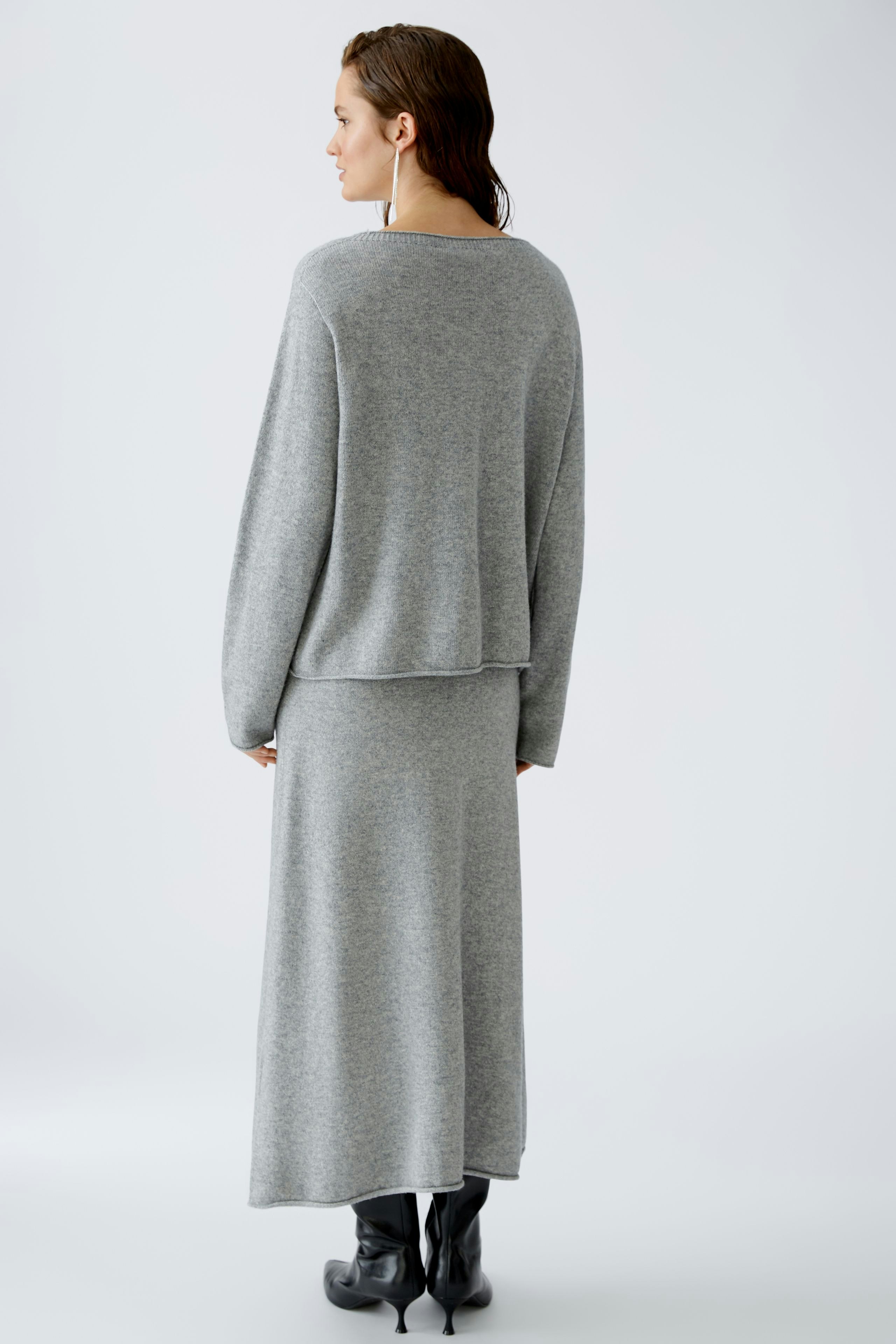 Damen-Pullover: Frau in grauem, lässigem Strickpullover mit elegantem Schnitt und langem Rock.