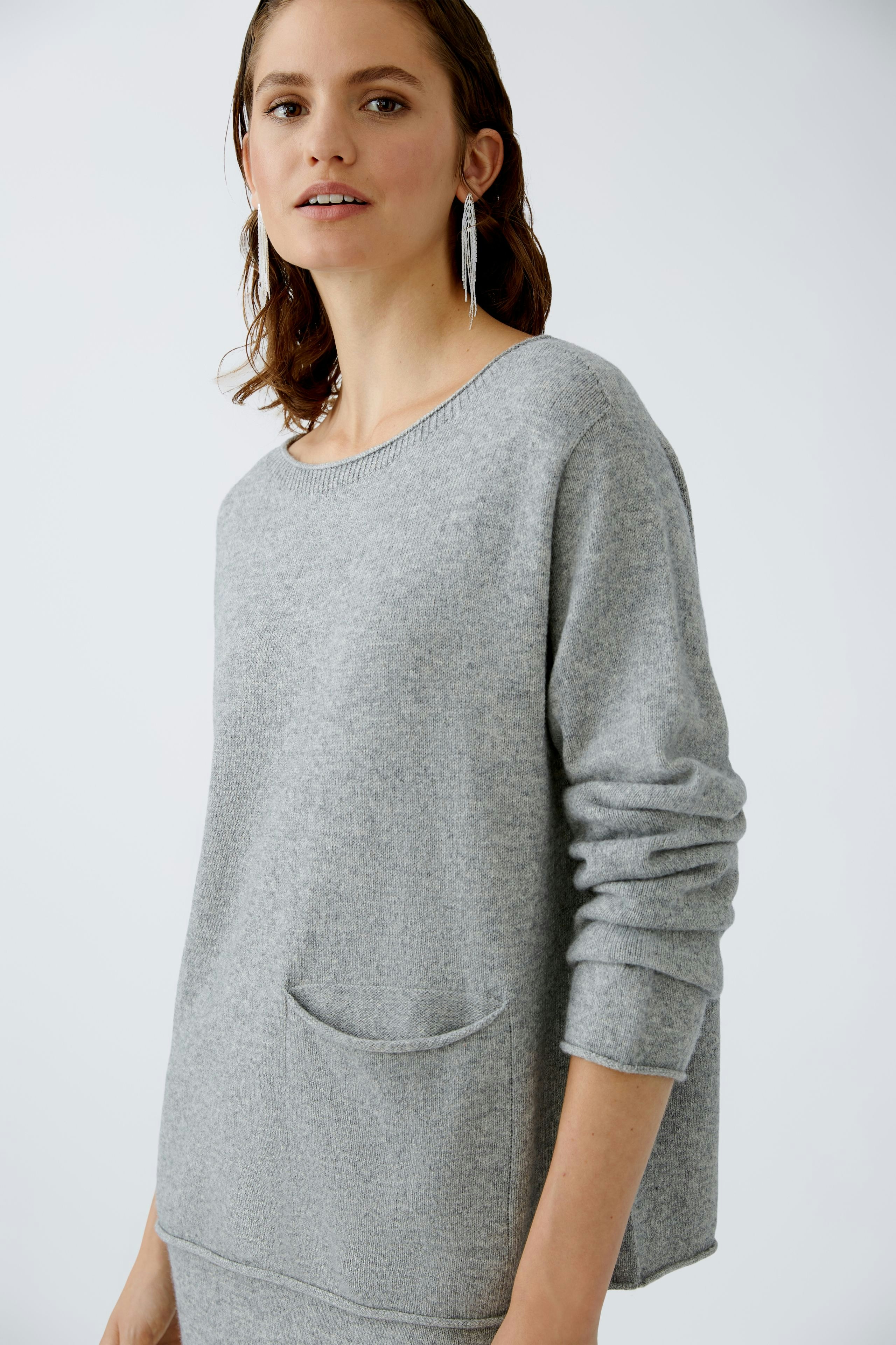 Eleganter Damen-Pullover: Frau in grauem Pullover mit lässiger Passform und praktischer Tasche.