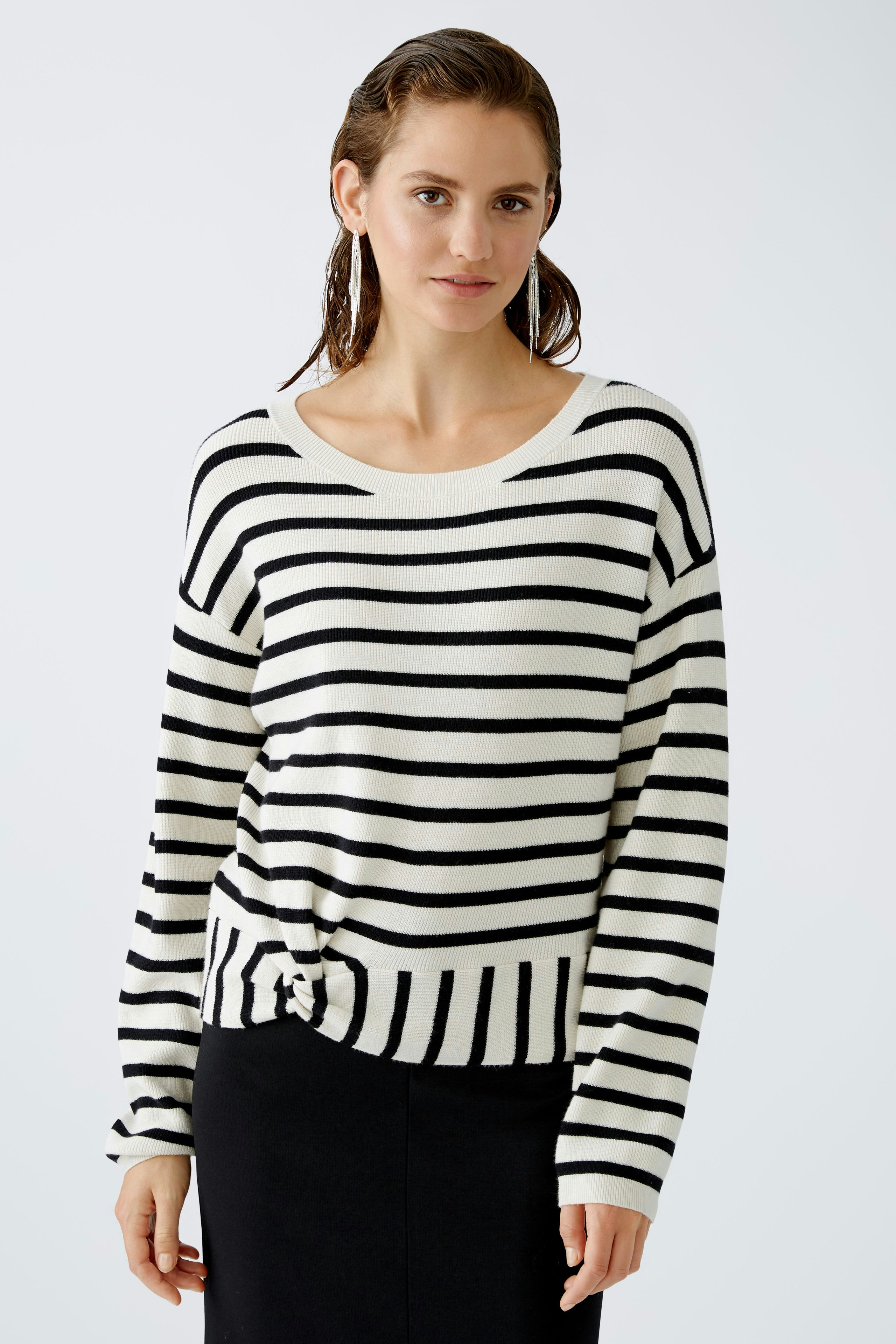 Modern women's pullover: A woman in a striped pullover with a knotted front, exuding casual elegance.