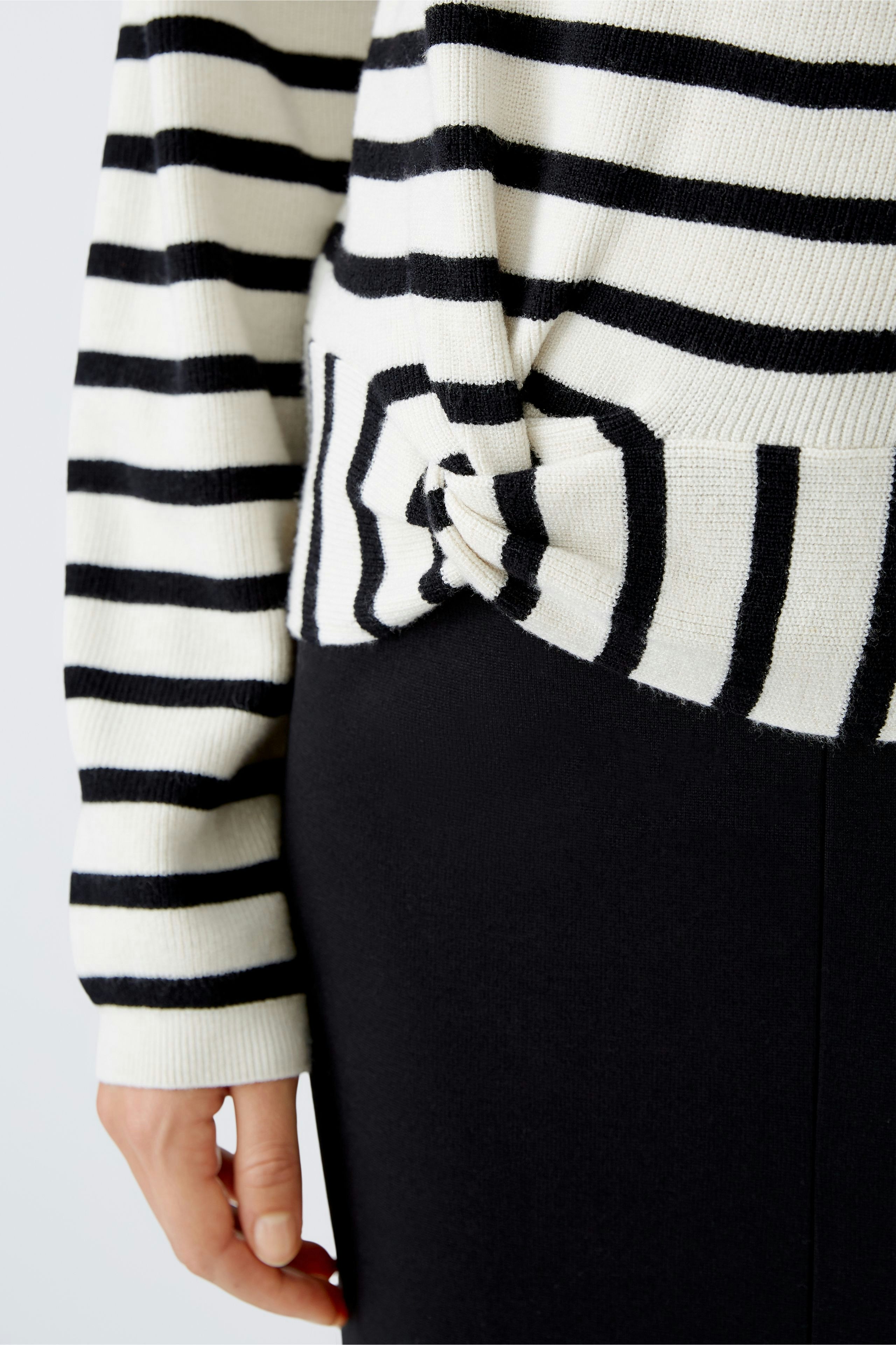 Stylish women's pullover: Close-up of a woman in a striped pullover, showcasing a chic and casual look.