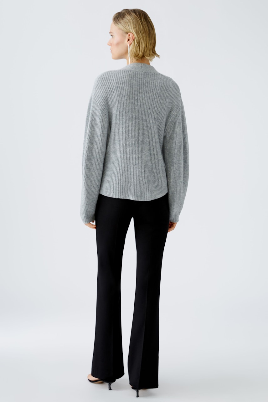 Stylish women's cardigan: A woman in a cozy gray cardigan paired with sleek black pants.