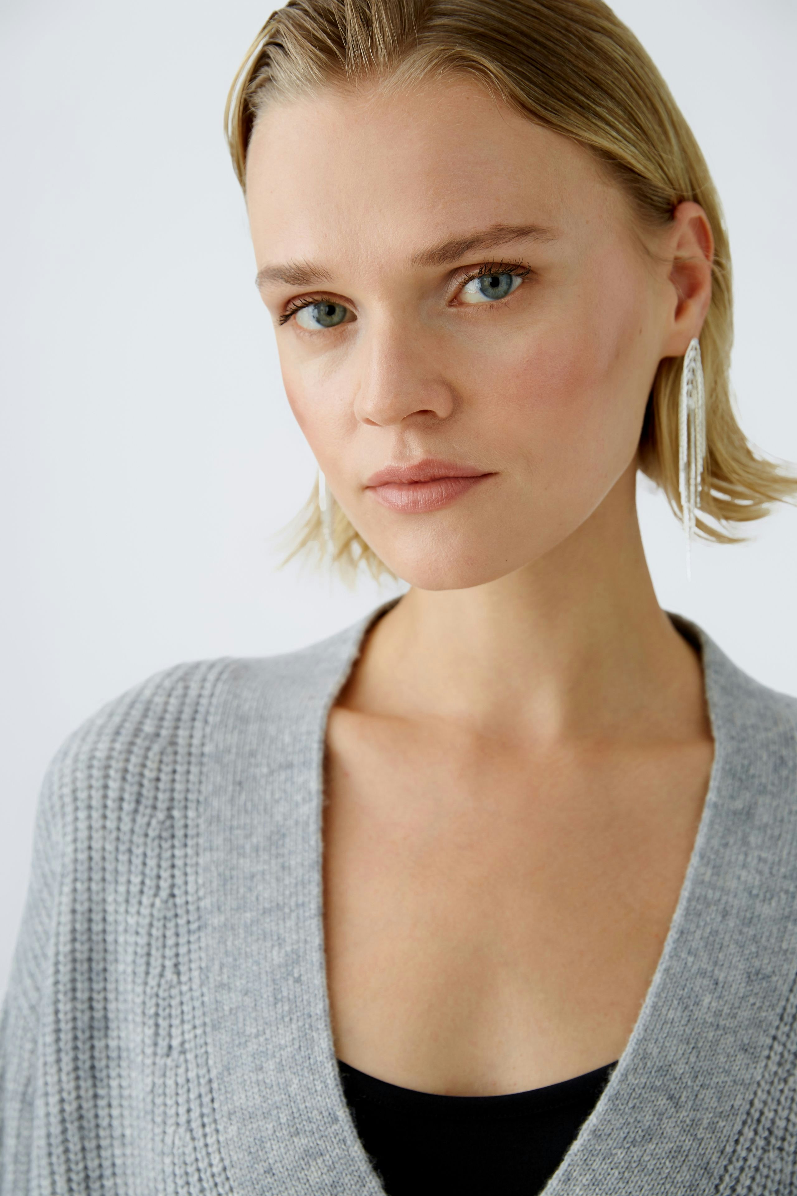 Stylish women's cardigan: A woman in a soft gray cardigan, exuding elegance and comfort.