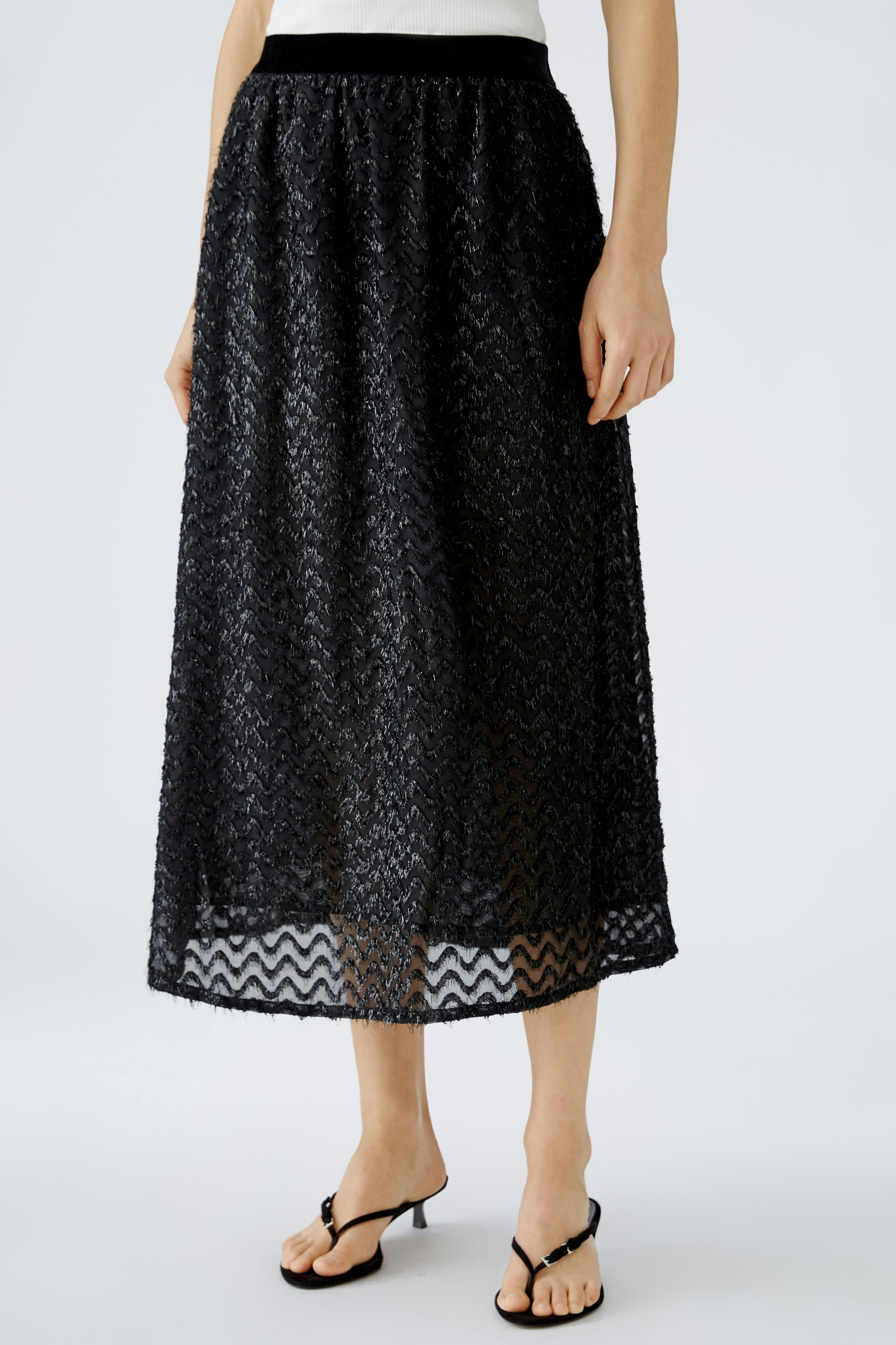 Elegant black skirt: Woman in a flowing, patterned skirt with a comfortable waistband, exuding style.