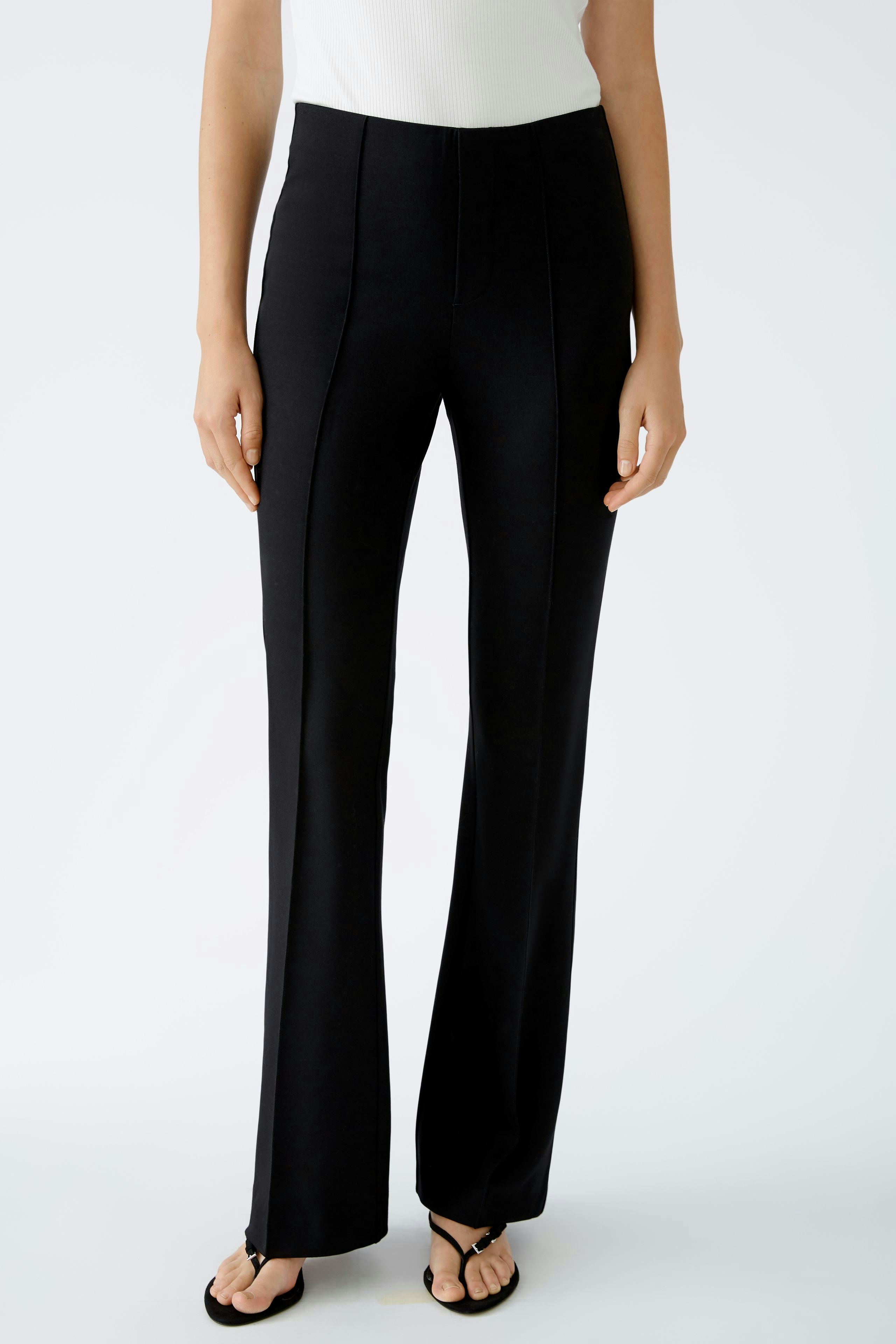 Chic flared trousers: A woman in sleek black flared pants, showcasing a modern and elegant style.