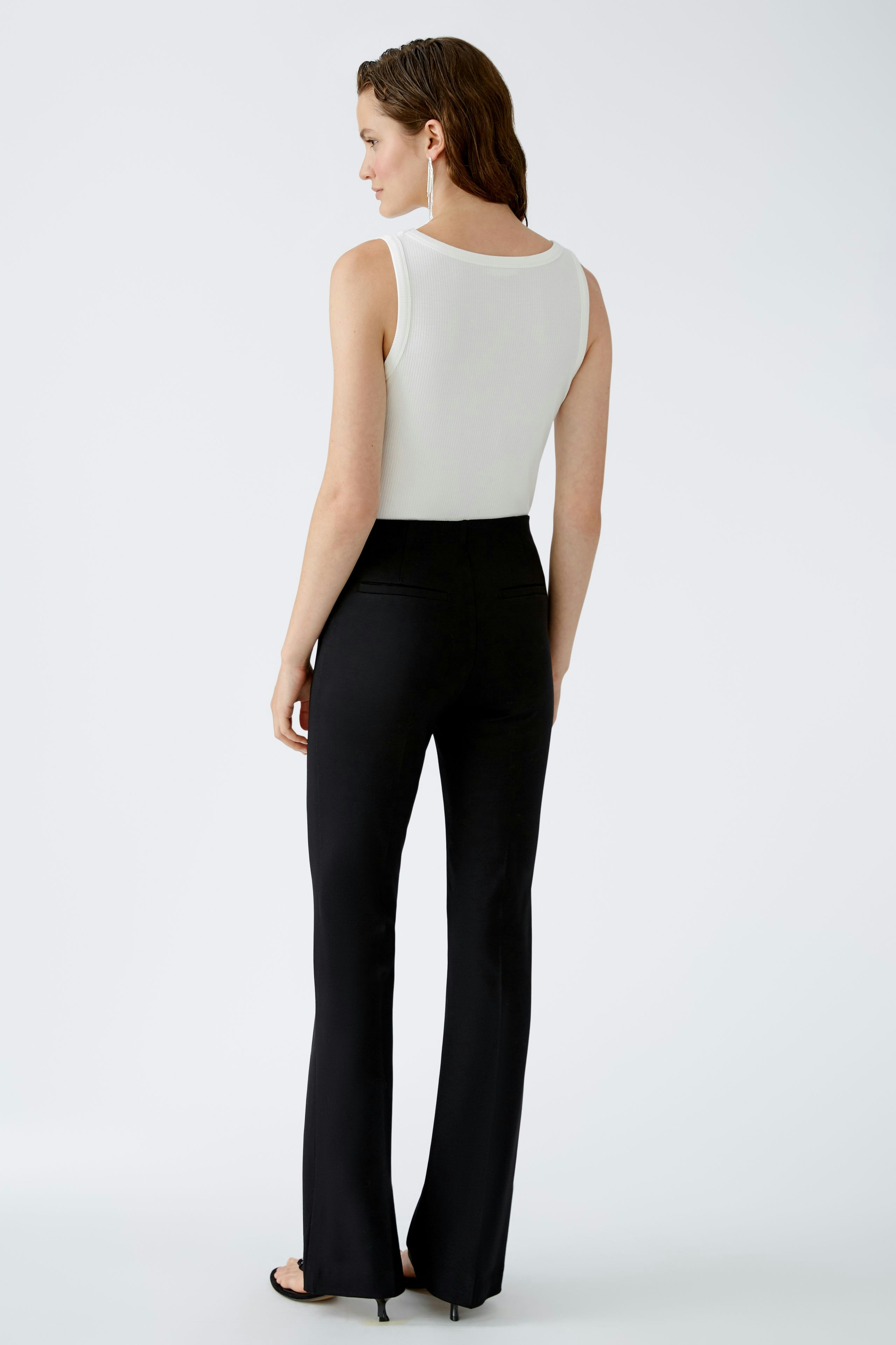 Chic flared trousers: A woman in sleek black flared trousers, showcasing a modern and stylish silhouette.