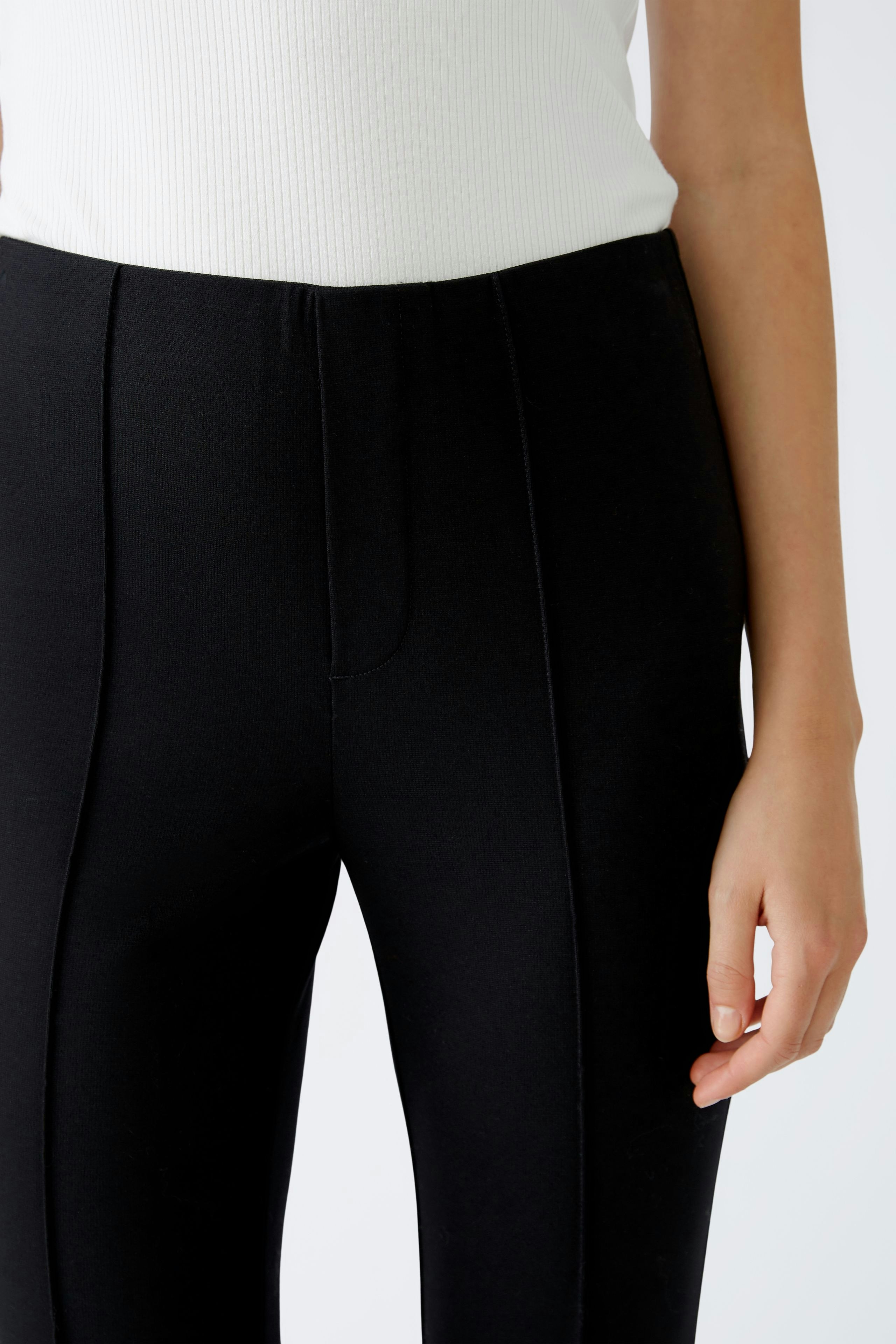Chic flared trousers: A woman in sleek black flared pants, perfect for a stylish look.