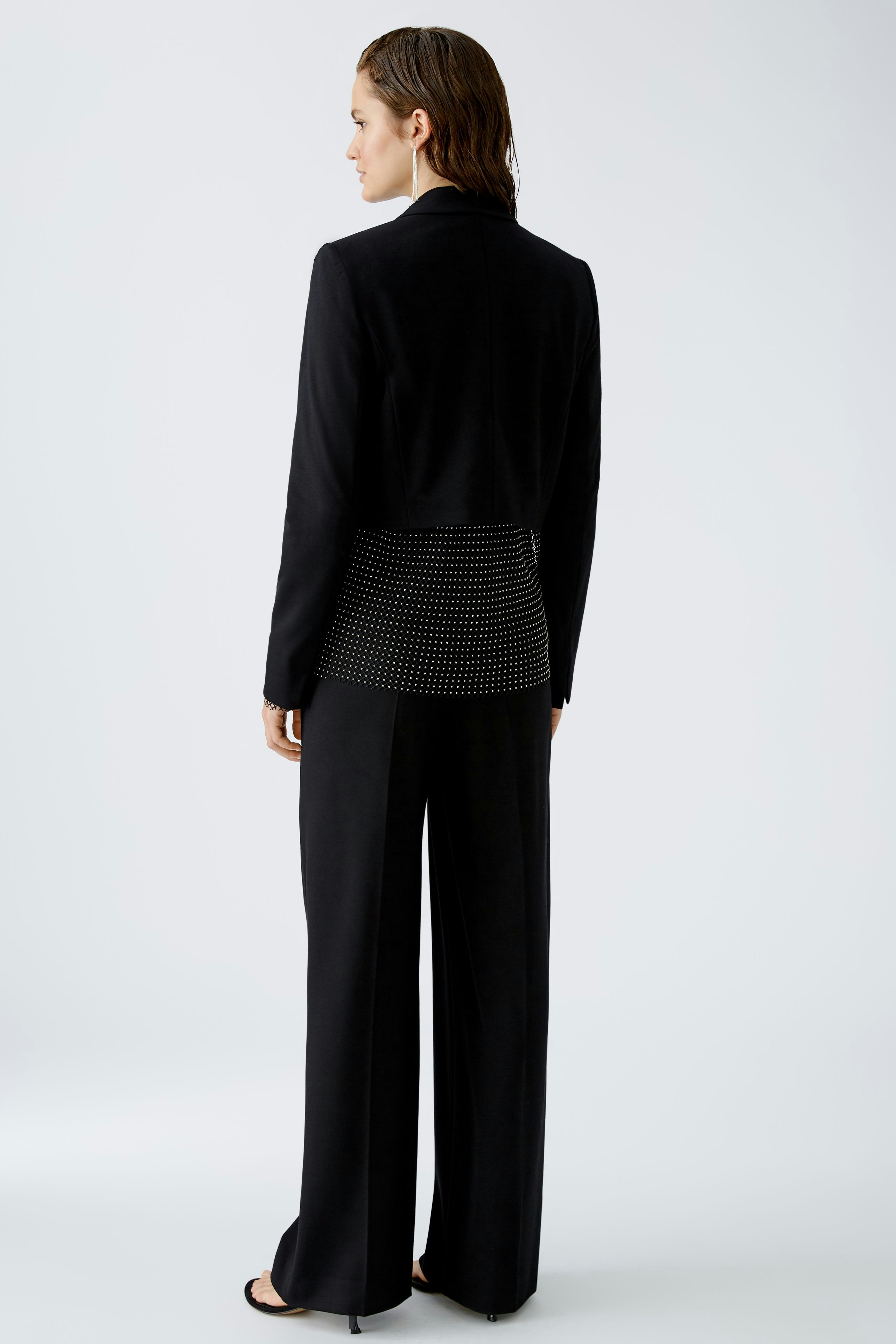 Eleganter Damen-Blazer: Frau in schwarzem Blazer mit modernem Design und lässiger Passform.