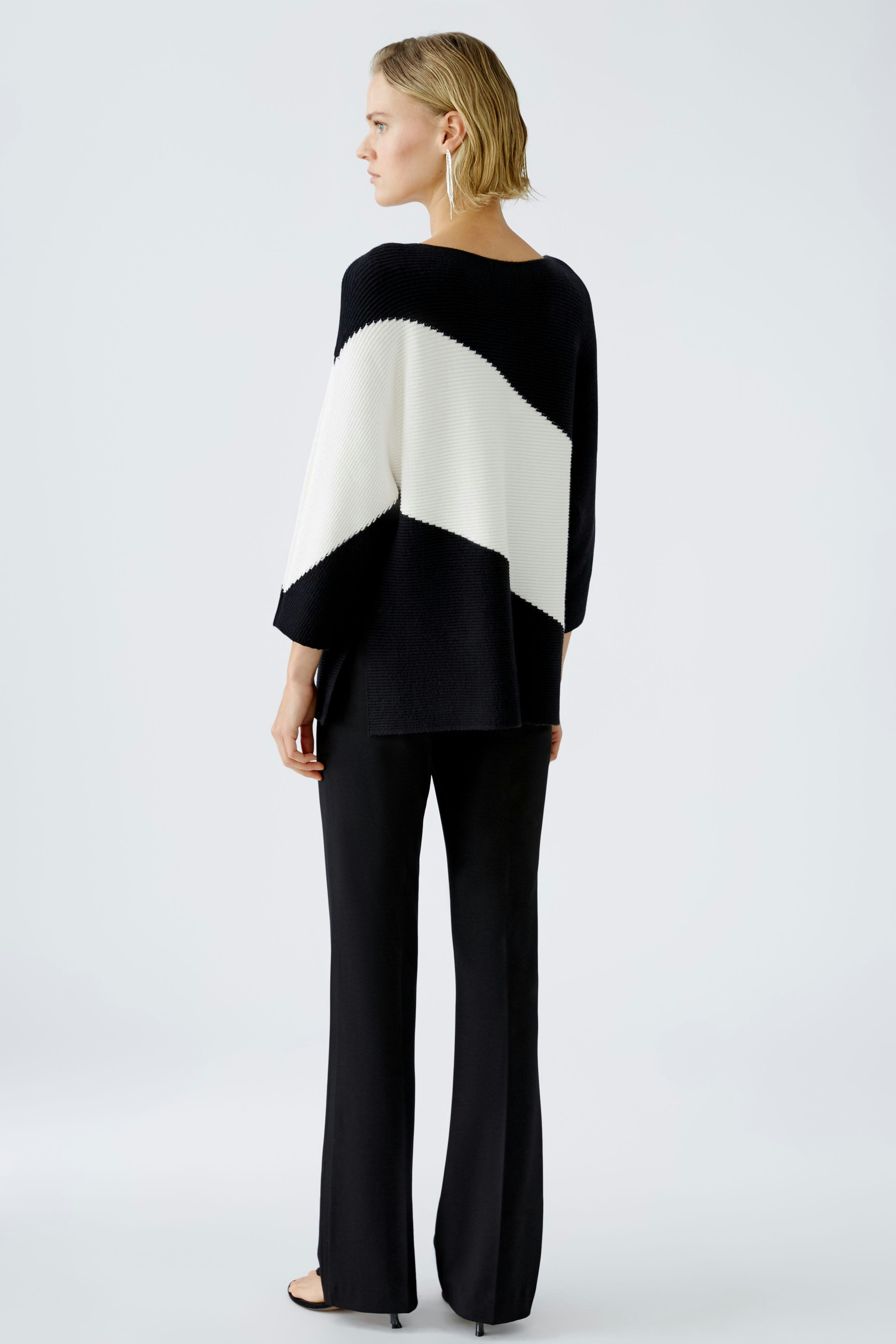 Stylish women's pullover: A woman in a black and white striped pullover, exuding elegance.