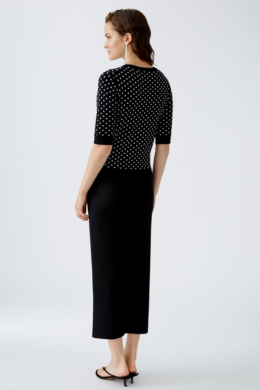 Stylish women's pullover: A woman in a black polka dot pullover, showcasing a chic and modern look.