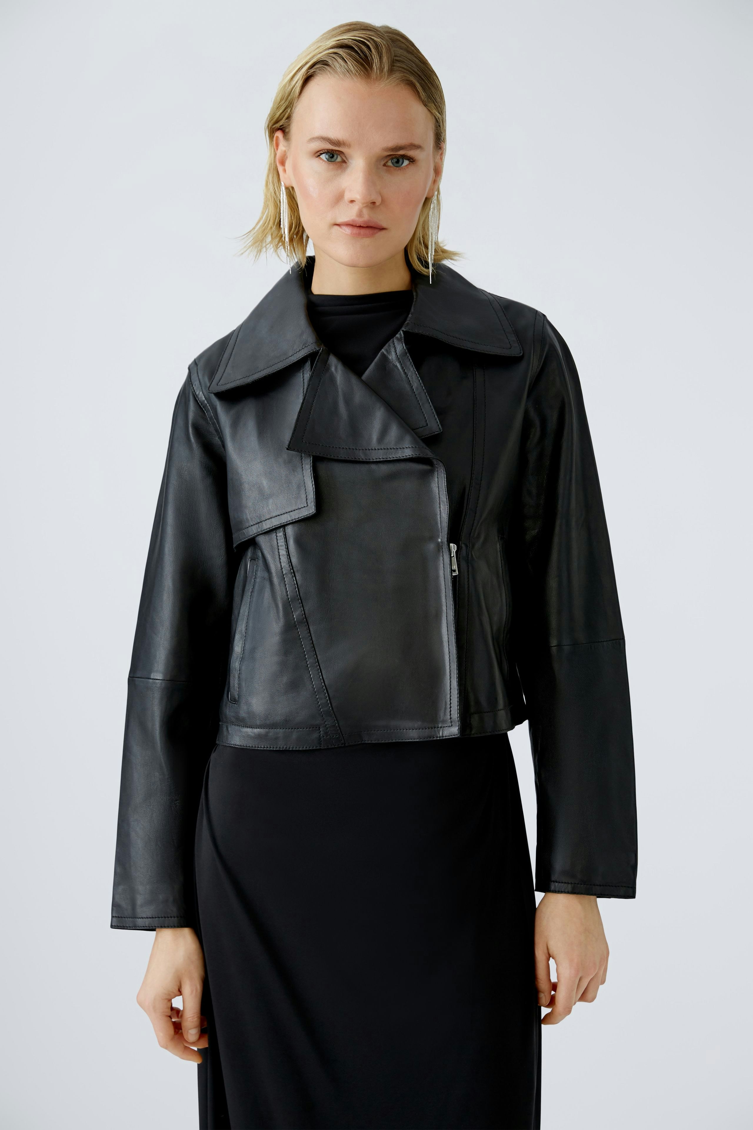 Stylish biker jacket: Confident woman in a black leather biker jacket, paired with a sleek dress.