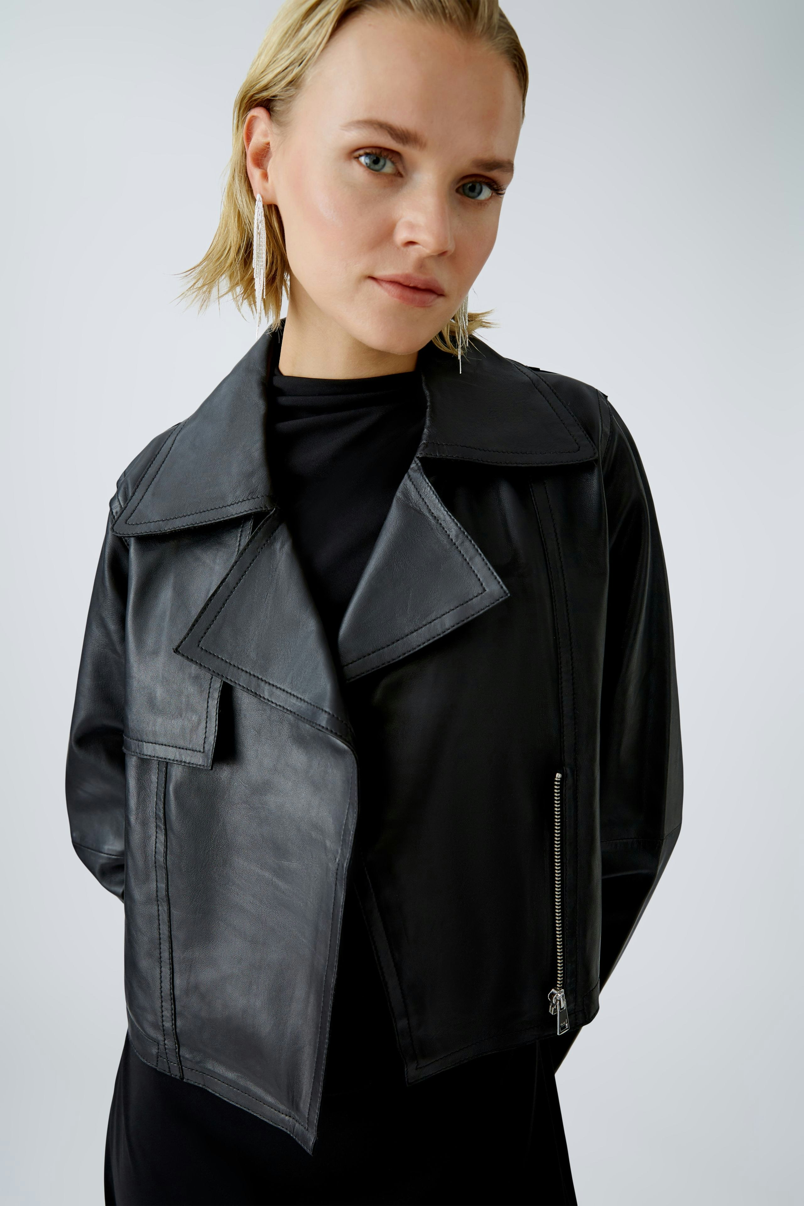 Stylish biker jacket: Confident woman in a black leather biker jacket, showcasing a modern look.