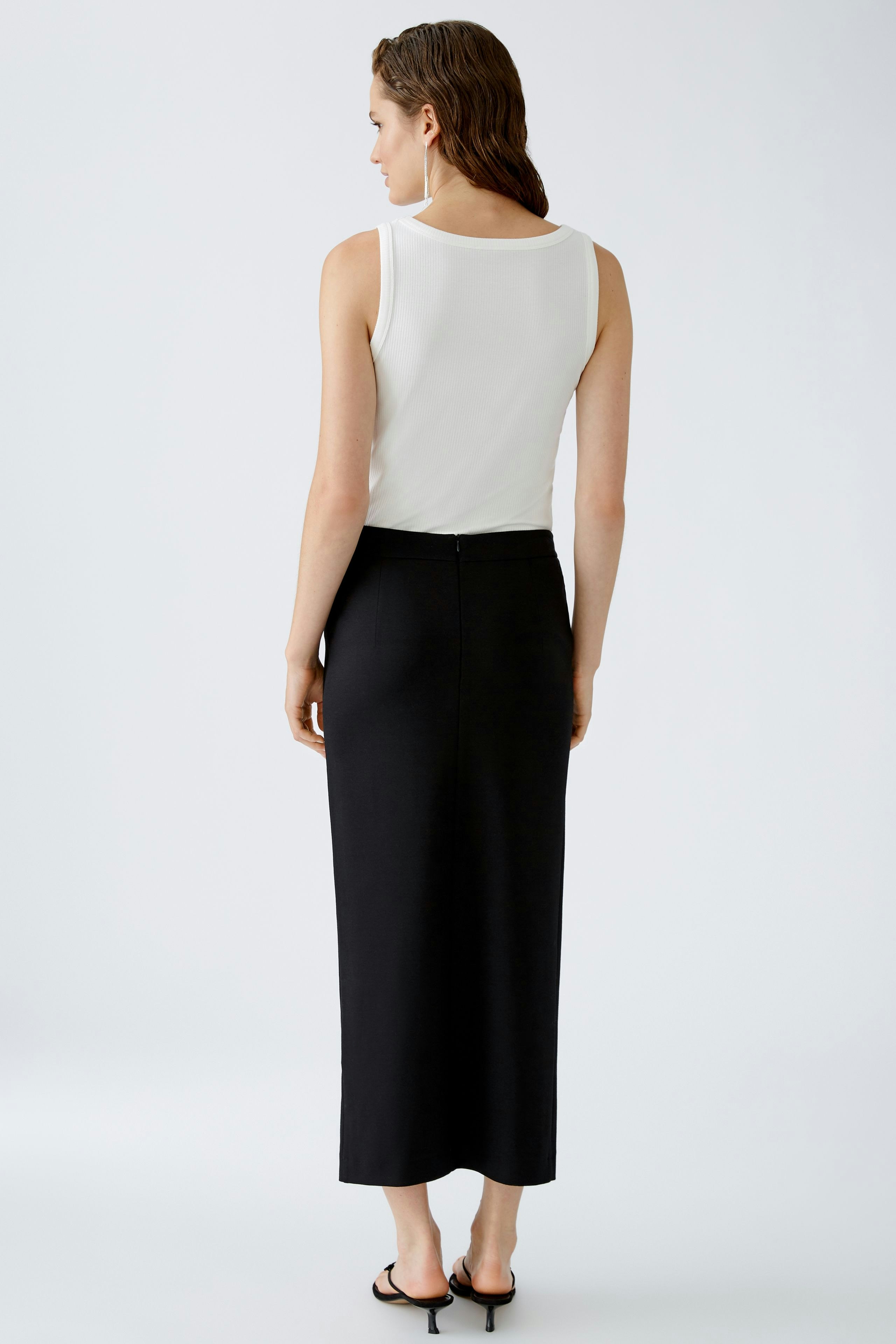 Elegant pencil skirt: Woman in a sleek black pencil skirt, showcasing a modern and sophisticated style.