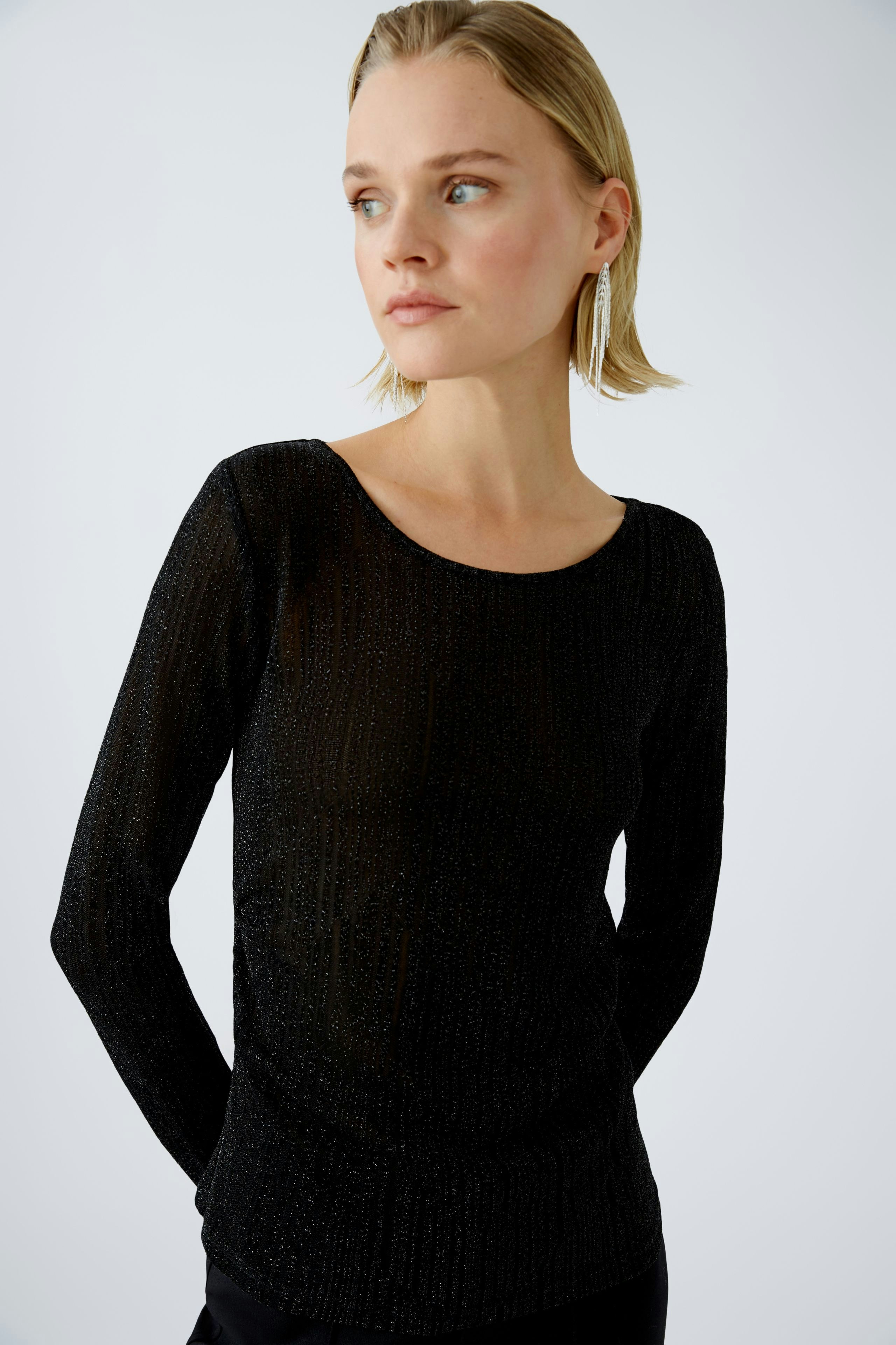 Elegant long-sleeve shirt: Woman in a black pullover with a subtle shimmer, exuding sophistication.