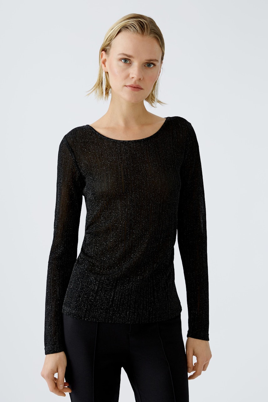 Elegant long-sleeve shirt: Woman in a black pullover with a subtle shimmer, exuding modern style.