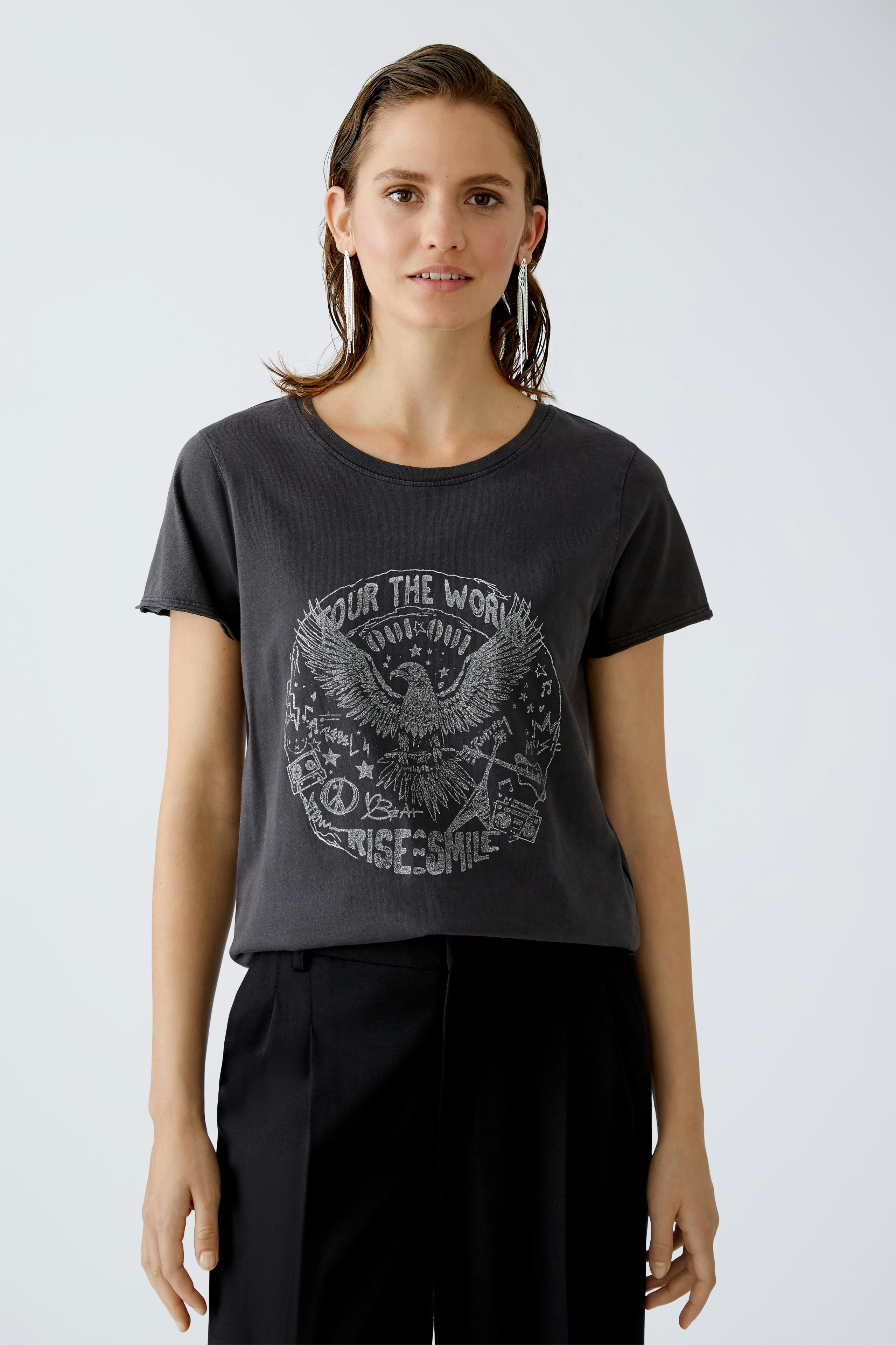 Casual women's T-shirt: Young woman in a dark graphic tee with a relaxed fit and stylish look.