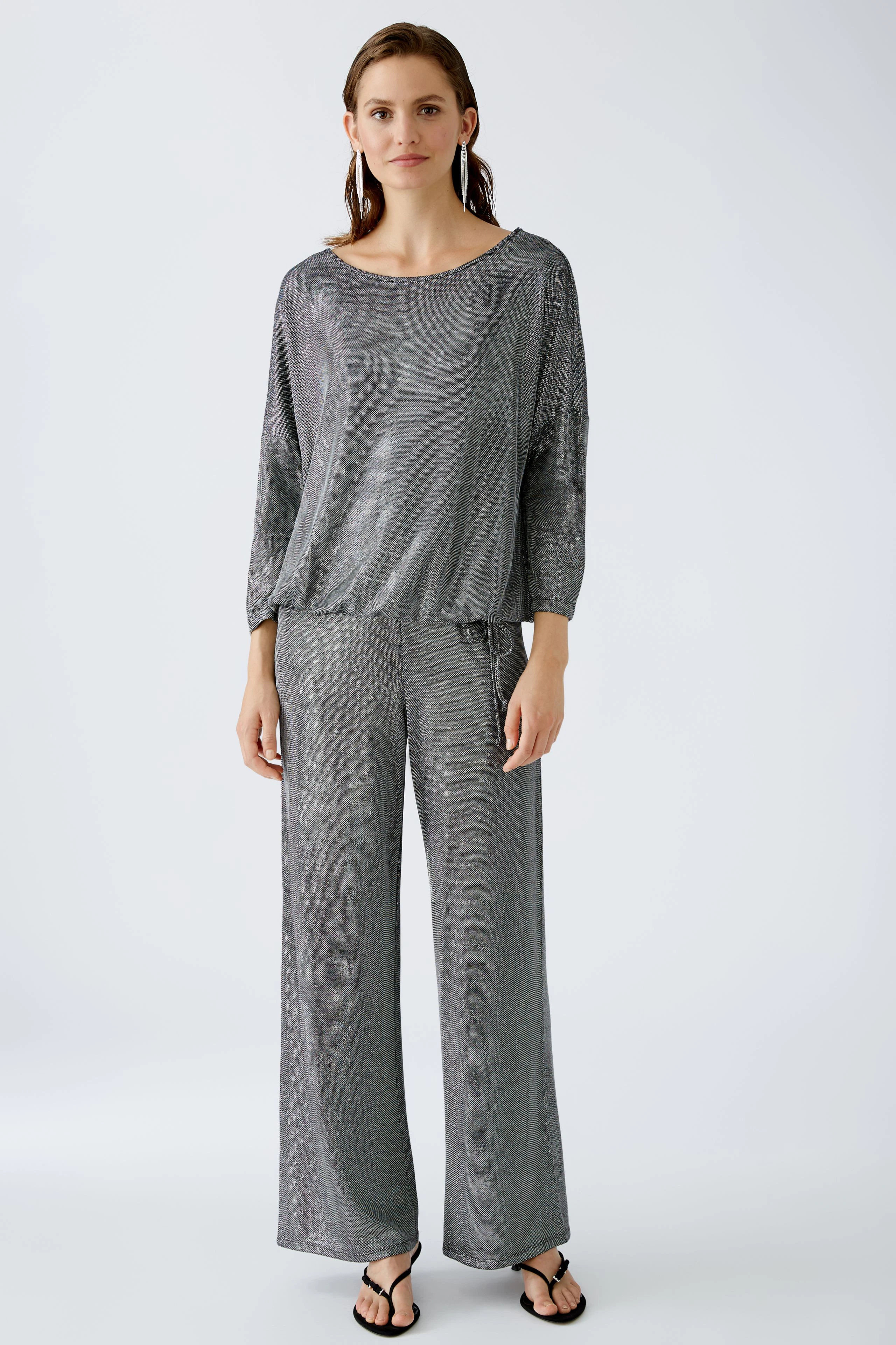 Elegantes Damen-T-Shirt: Frau in schimmerndem, grauem T-Shirt mit lässigem Schnitt und weichem Material.