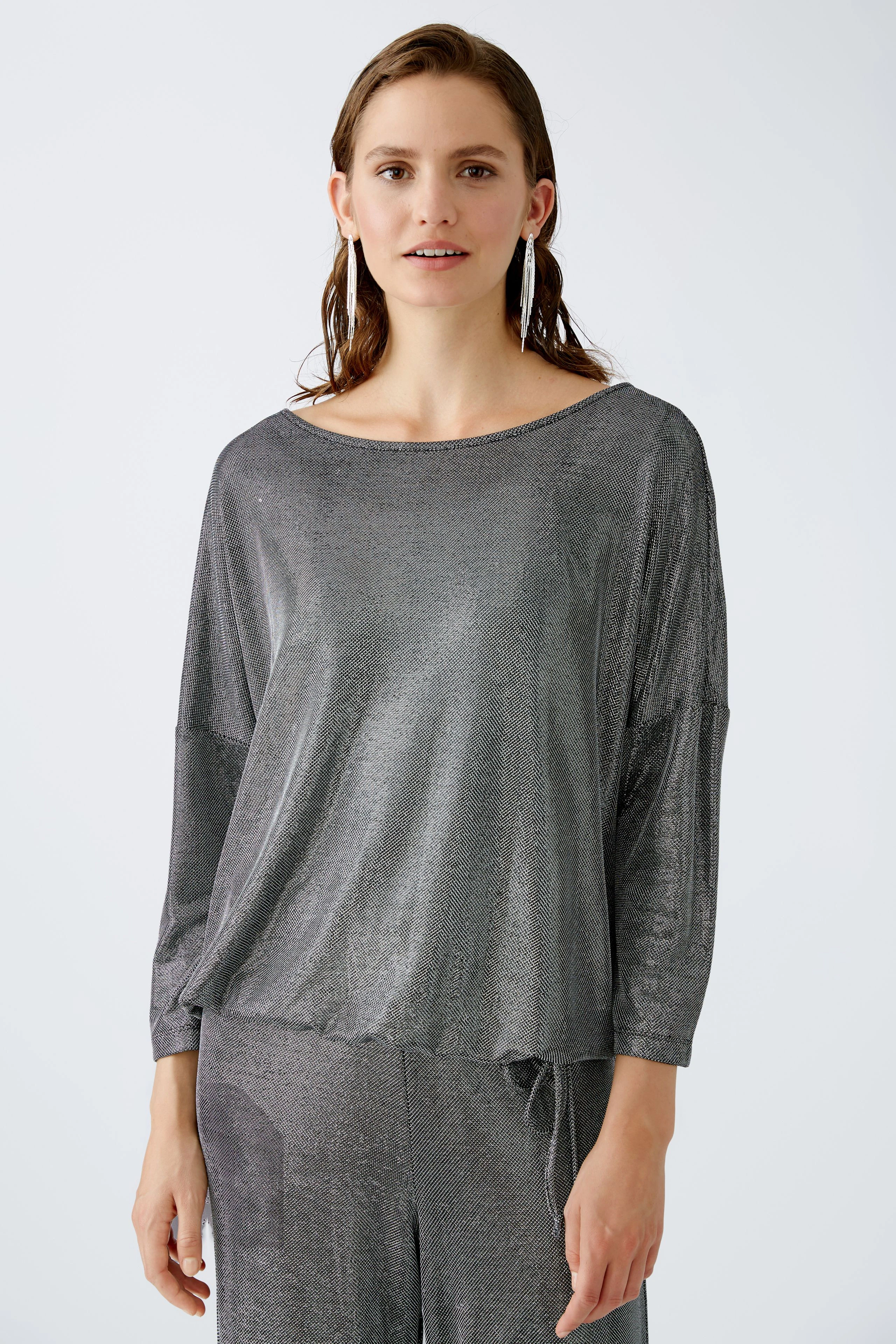 Elegantes Damen-T-Shirt: Frau in schimmerndem grauen Shirt mit lässigem Schnitt und Rundhalsausschnitt.