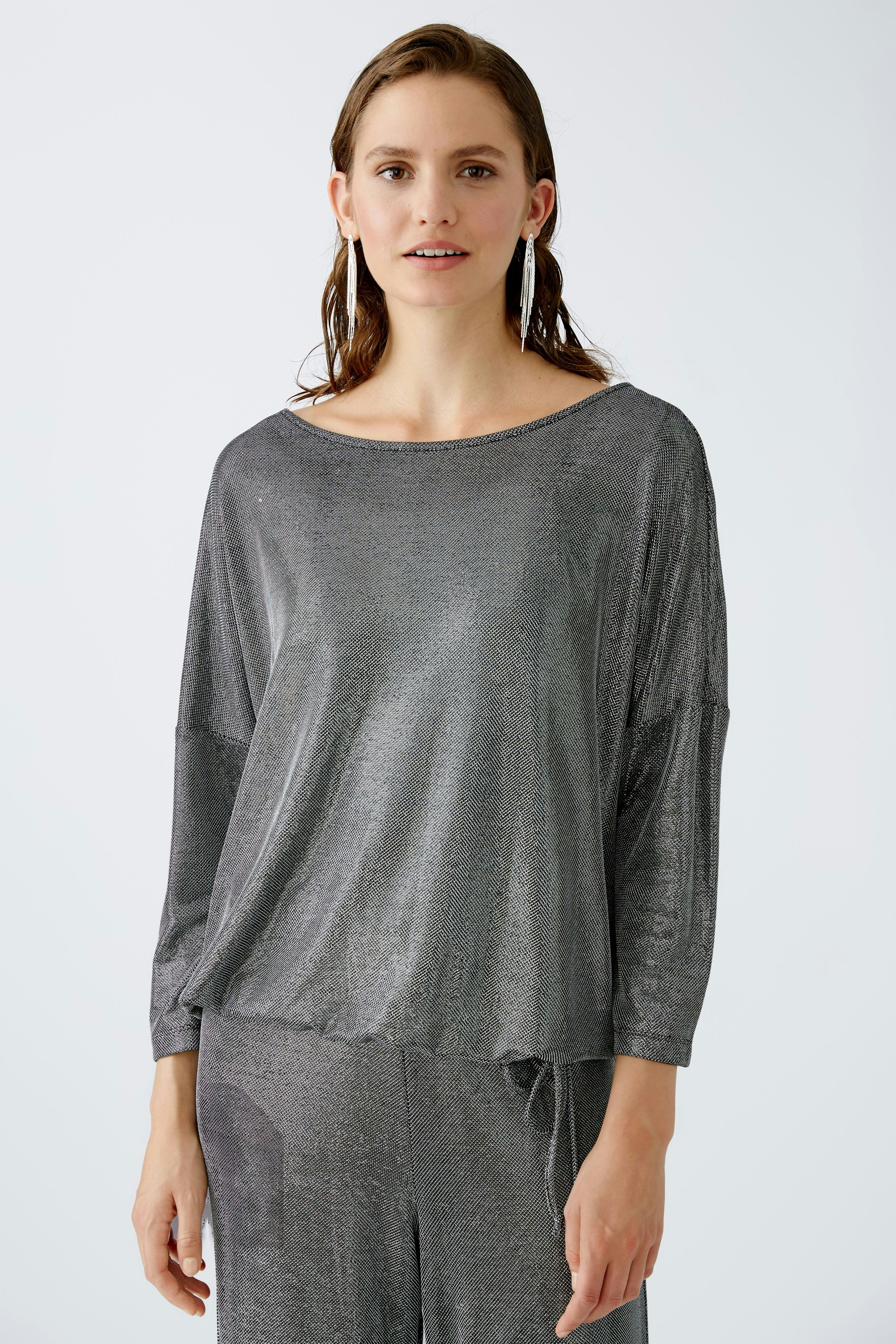 Elegantes Damen-T-Shirt: Frau in schimmerndem grauen Shirt mit lässigem Schnitt und Rundhalsausschnitt.