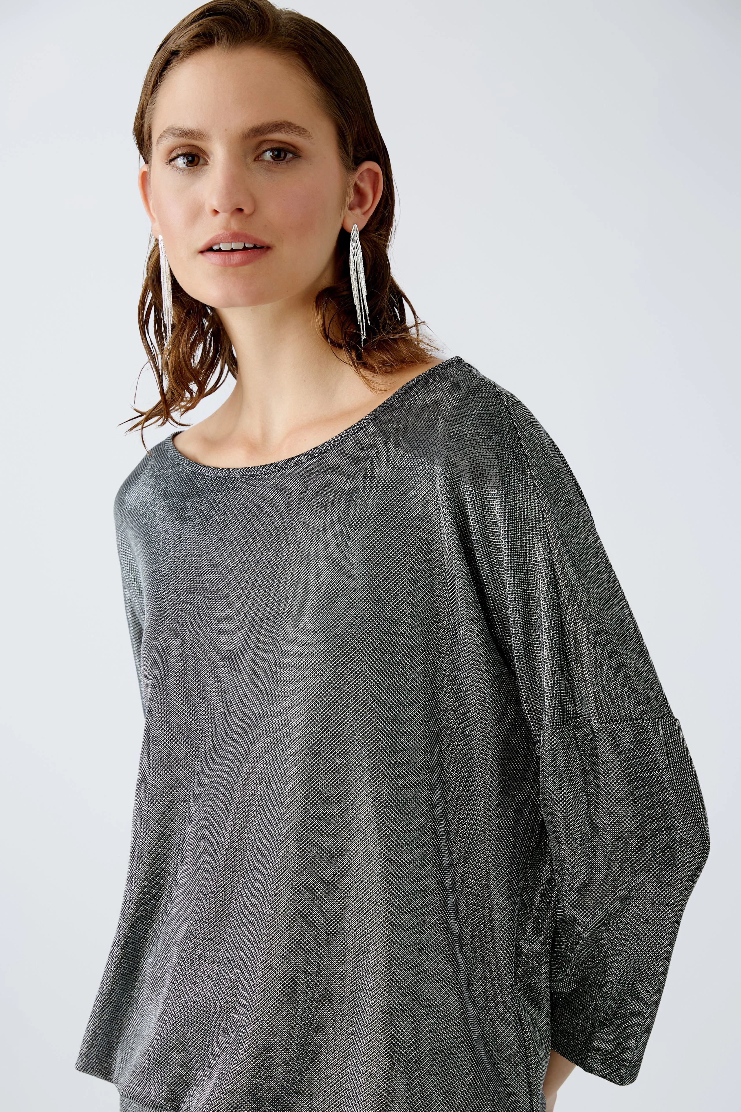 Elegantes Damen-T-Shirt: Frau in schimmerndem, grauem T-Shirt mit lässigem Schnitt und modernem Look.