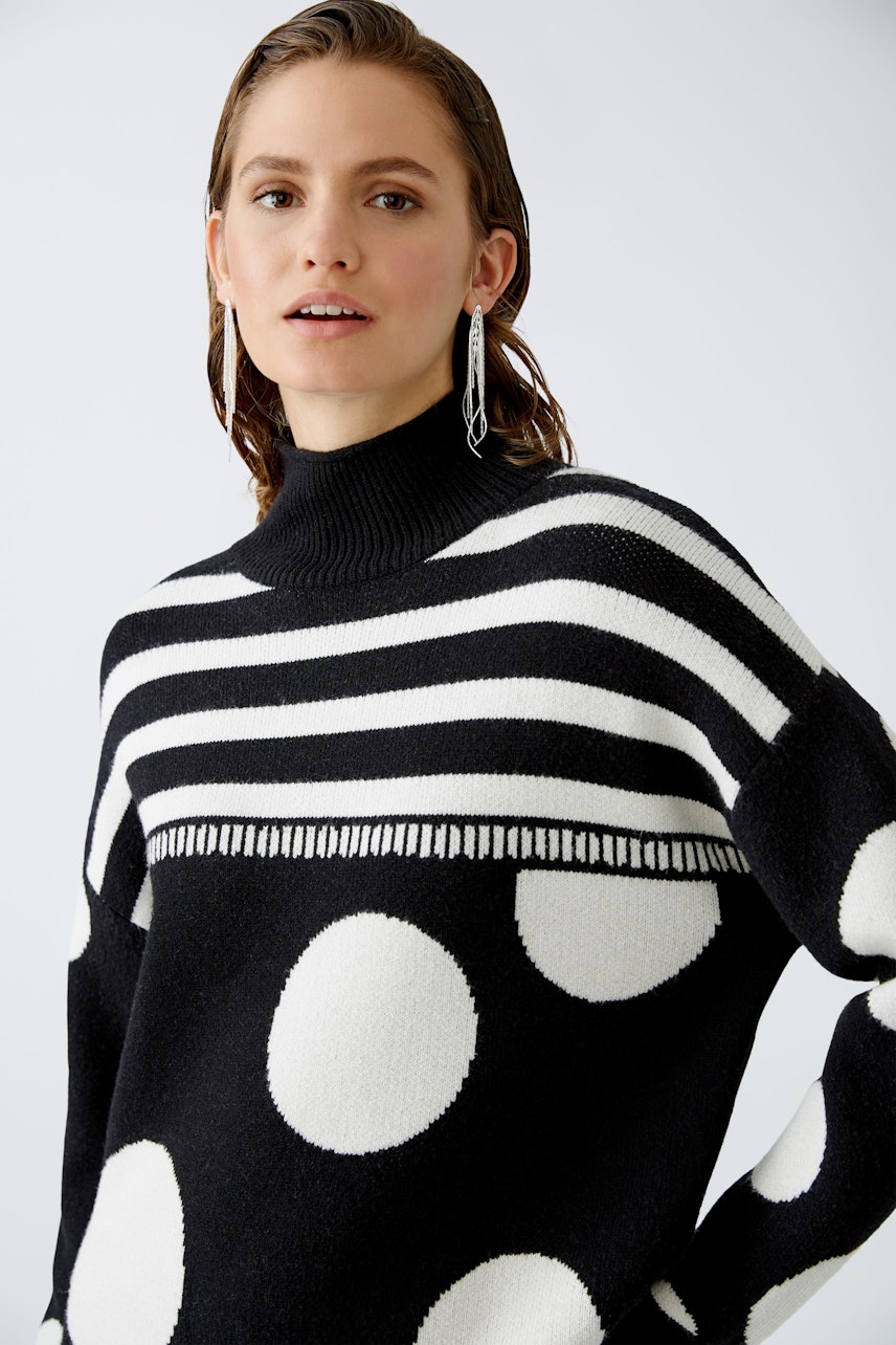 Modern women's pullover: A woman in a black and white striped pullover with polka dots.