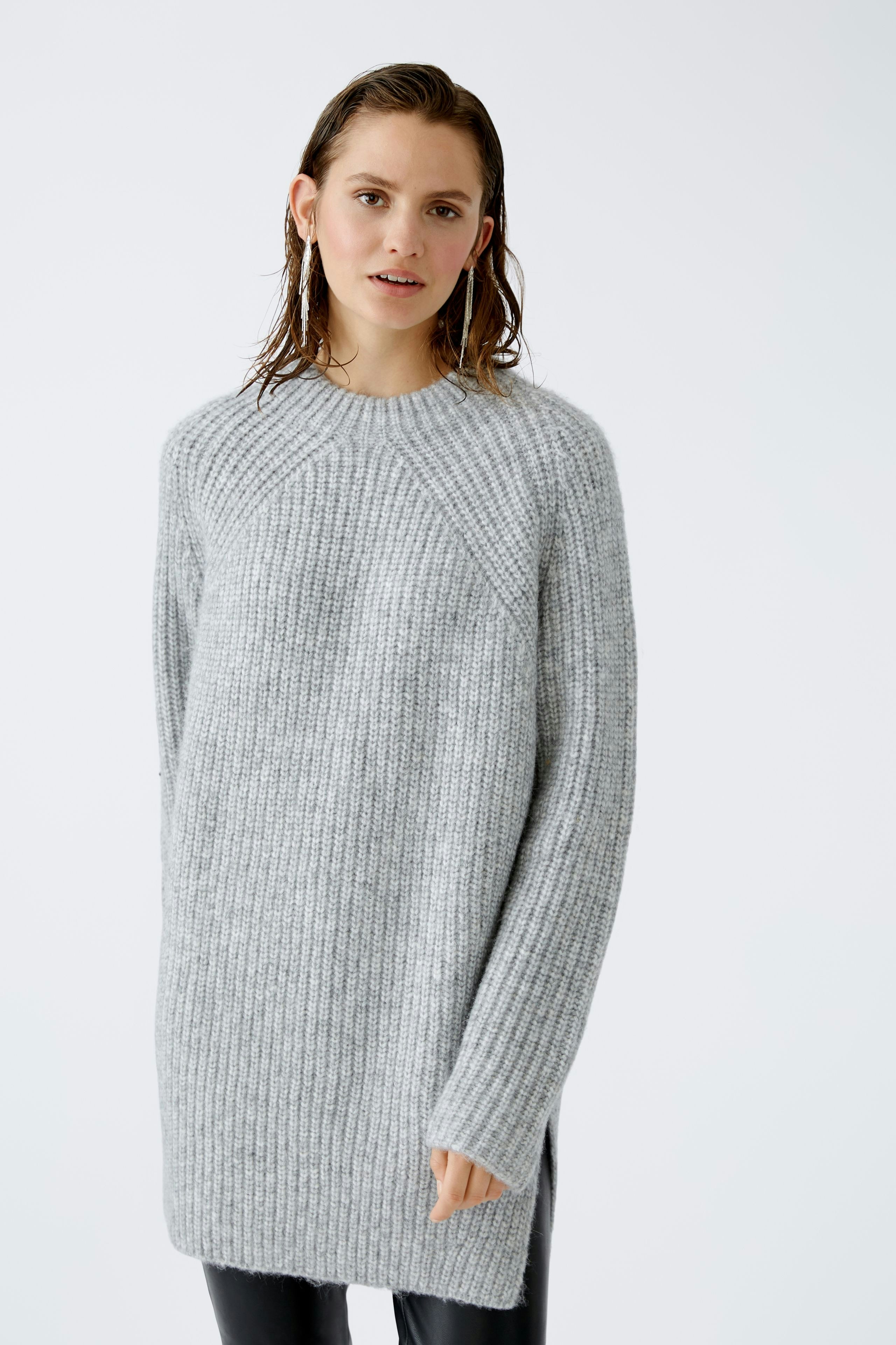 Modern women's pullover: A woman in a cozy gray pullover with a relaxed fit.