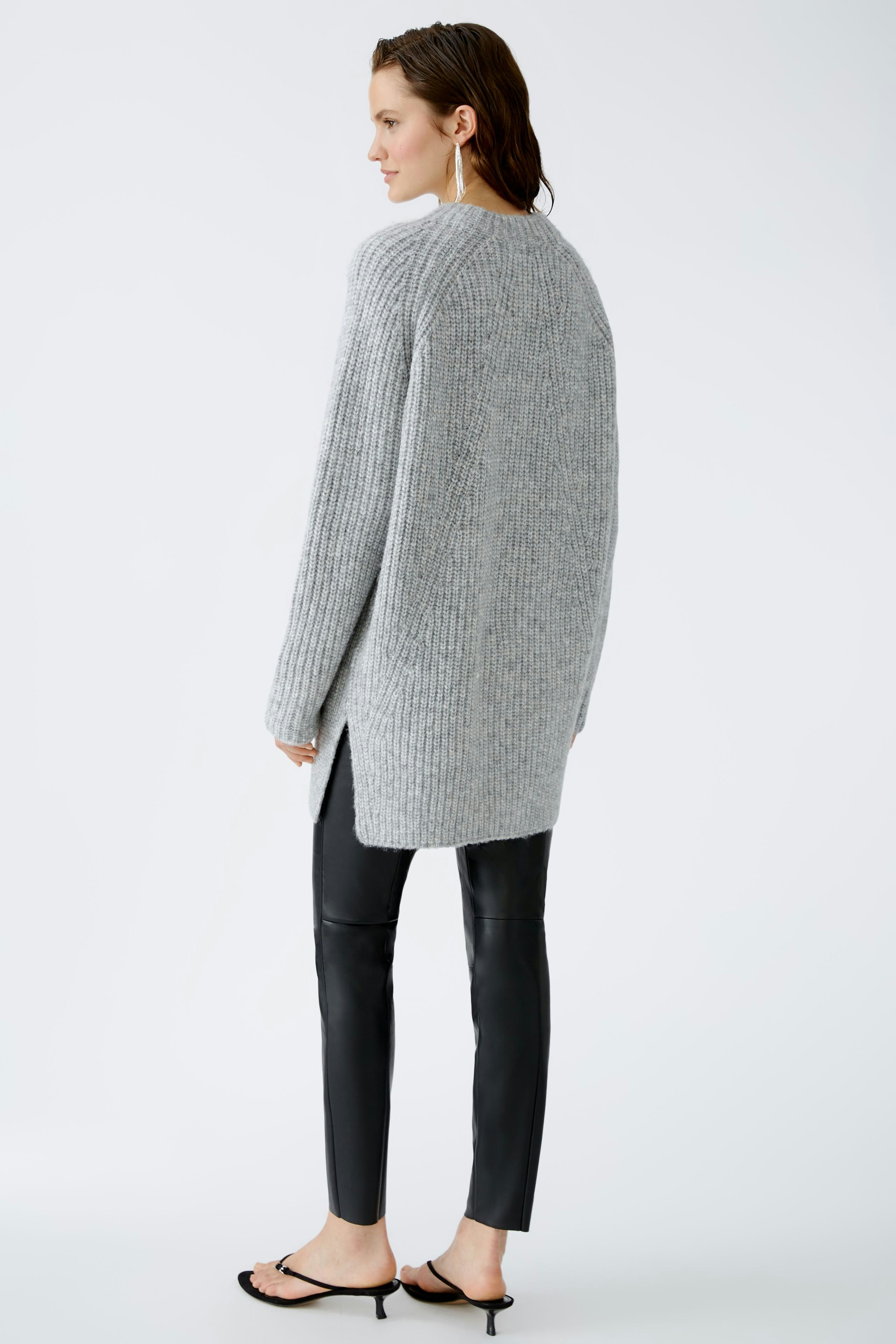 Stylish women's pullover: A woman in a cozy gray pullover with a relaxed fit, paired with sleek black pants.
