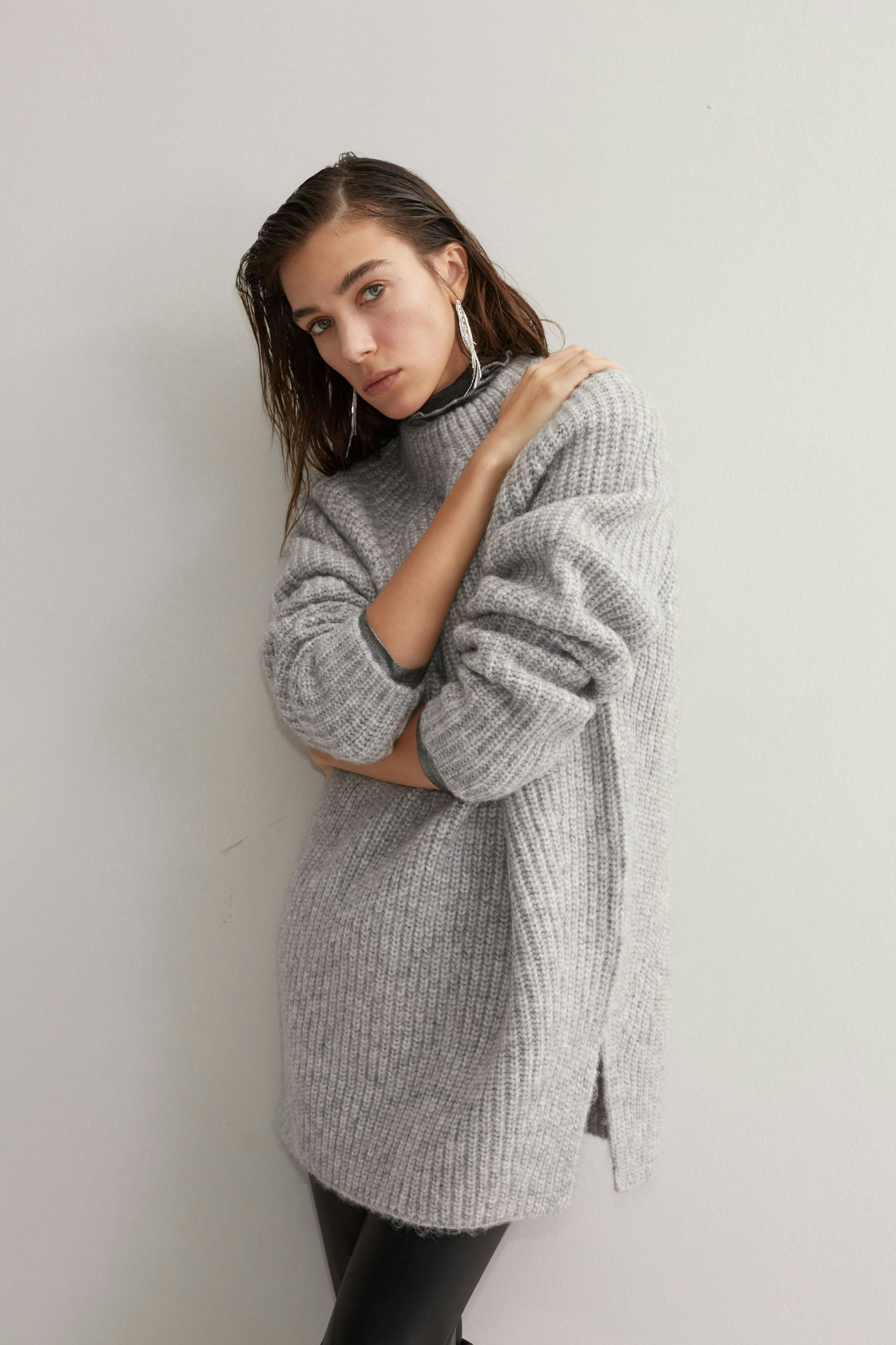 Modern women's pullover: Young woman in a cozy gray pullover with a relaxed fit.