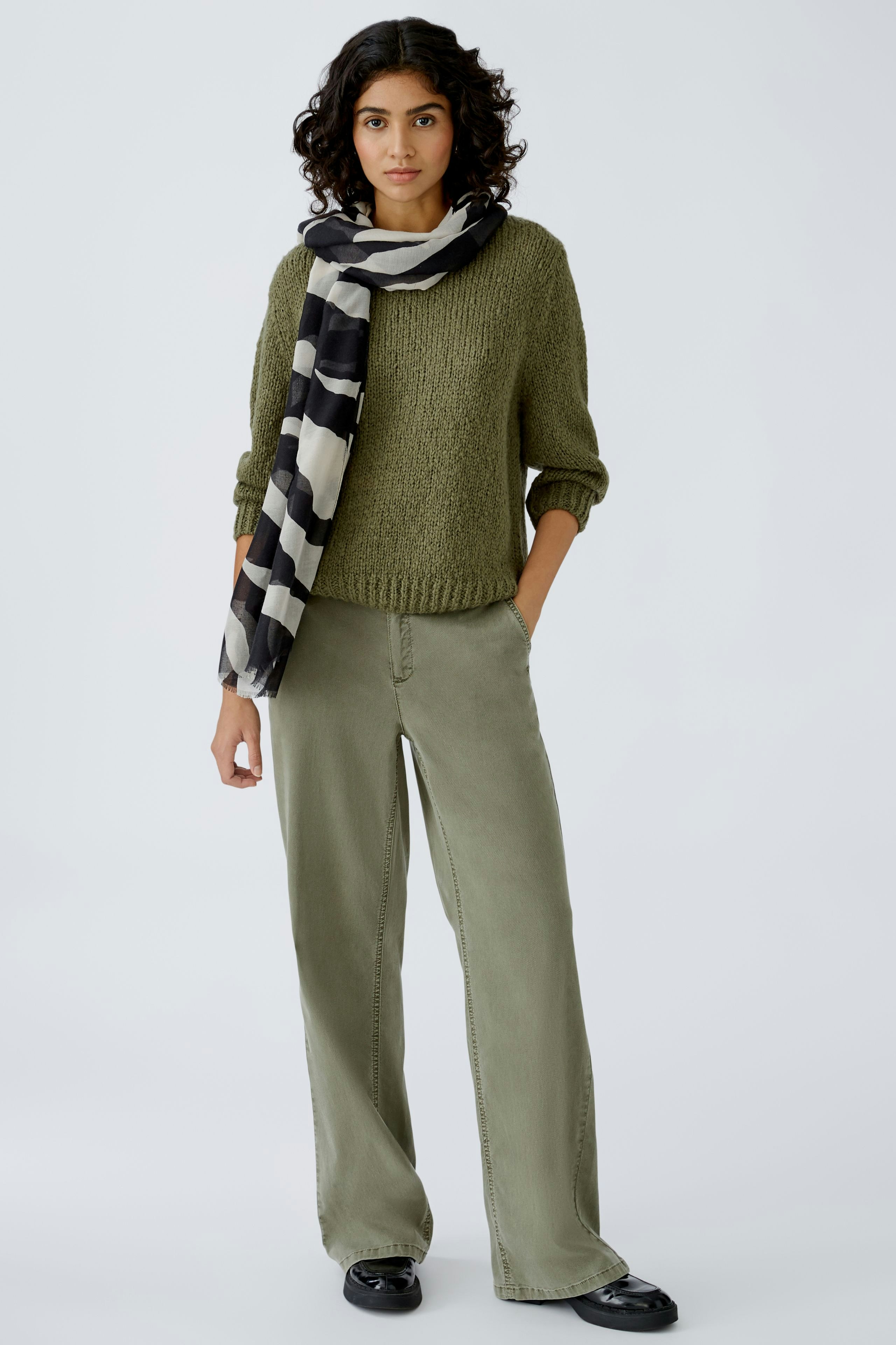 Stylischer Damen-Schal in Schwarz und Beige, lässig um den Hals drapiert.