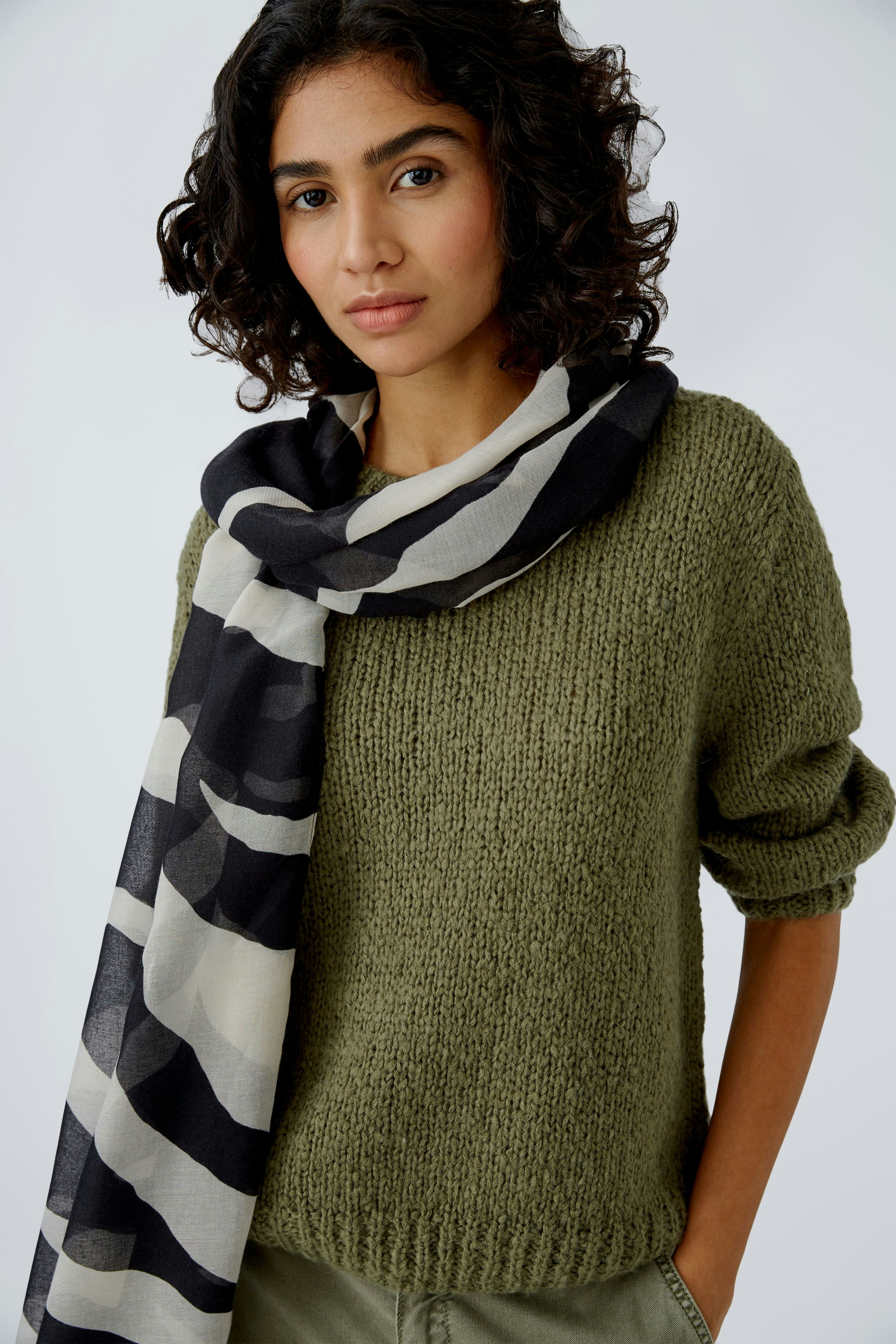 Eleganter Damen-Schal: Frau trägt einen modischen Schal in Schwarz und Beige, perfekt für jeden Anlass.