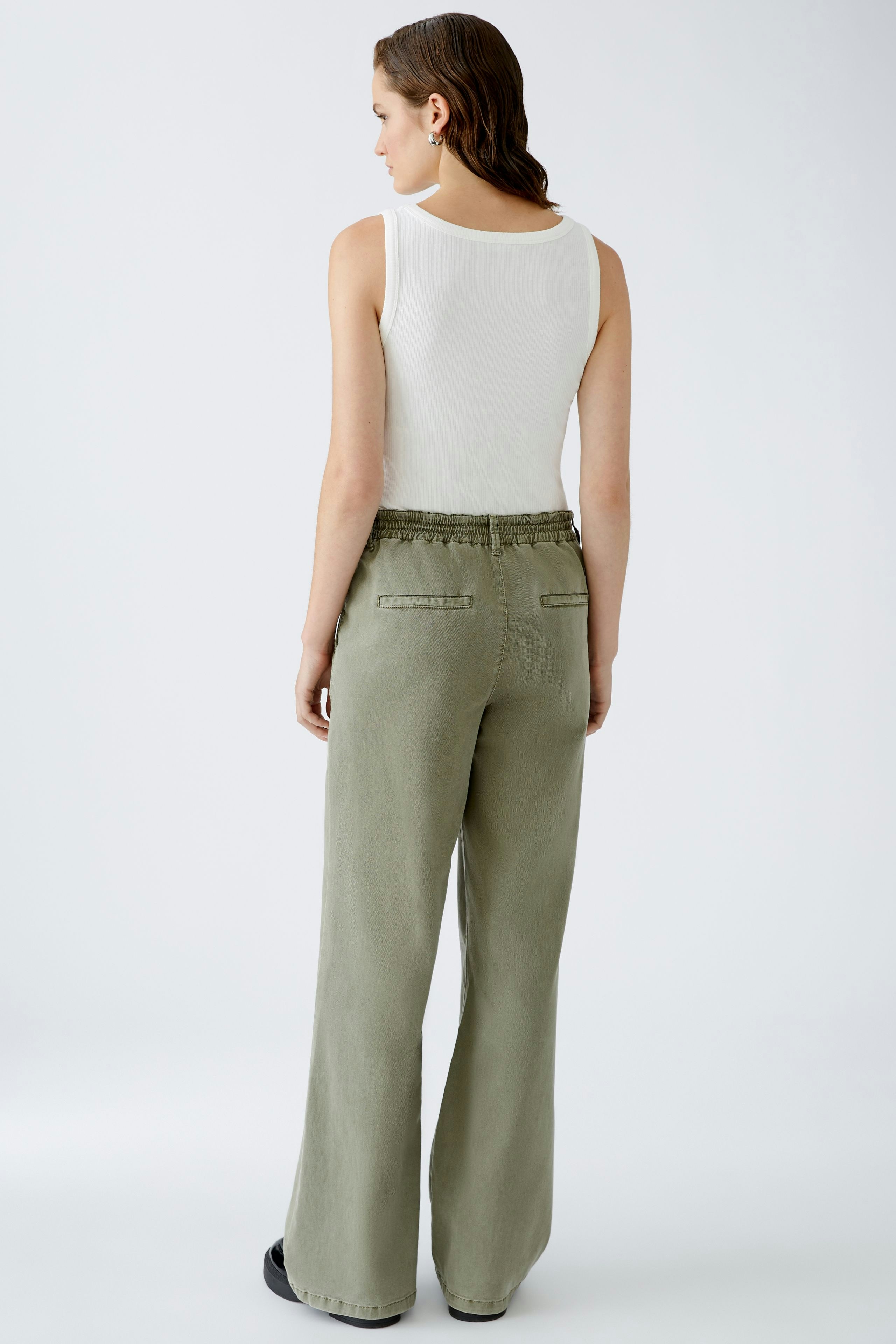 Stylish women's trousers: A woman in olive green wide-leg pants with a relaxed fit.