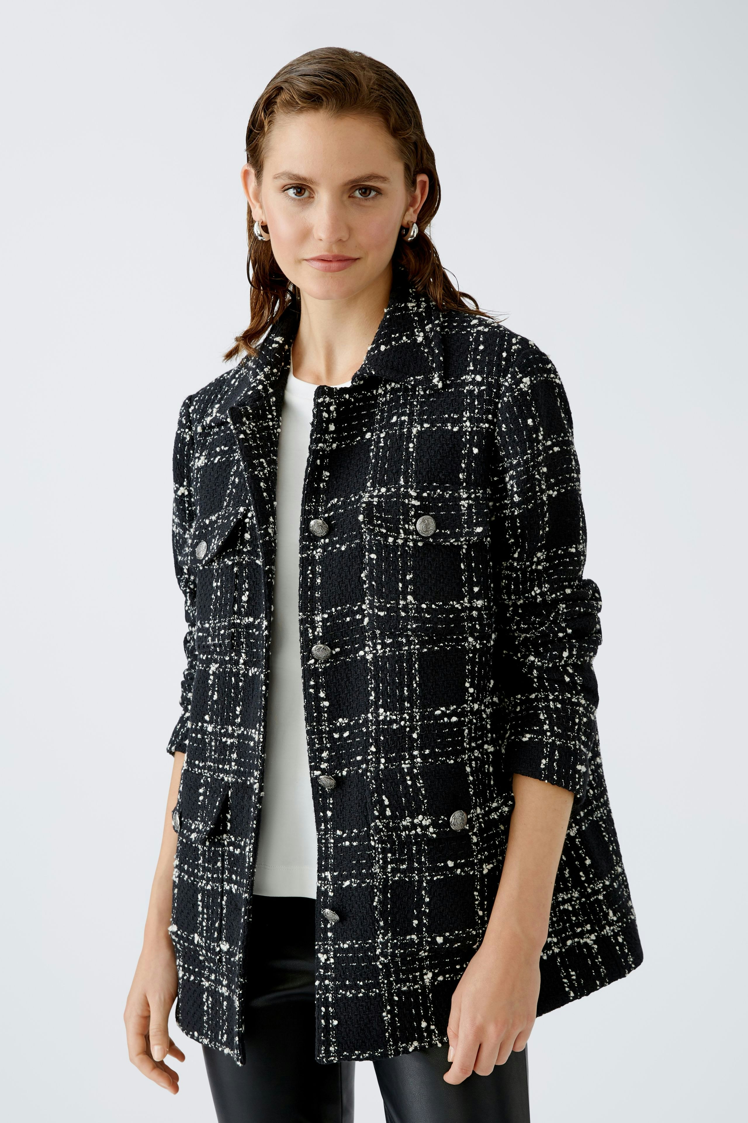 Stylish women's jacket: A woman in a black and white checked jacket with a relaxed fit.