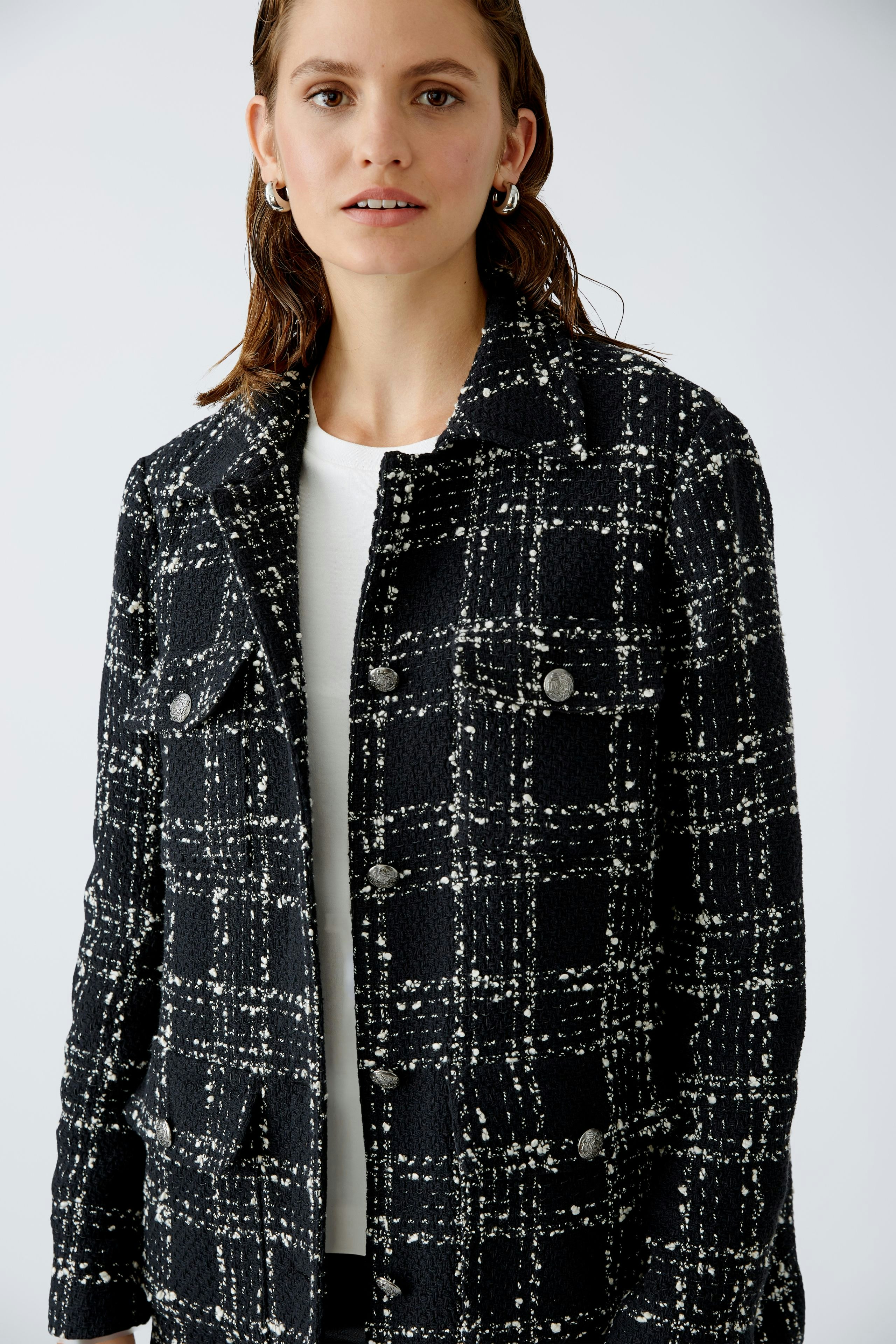Stylish women's jacket: A woman in a black and white checkered jacket with a classic design.