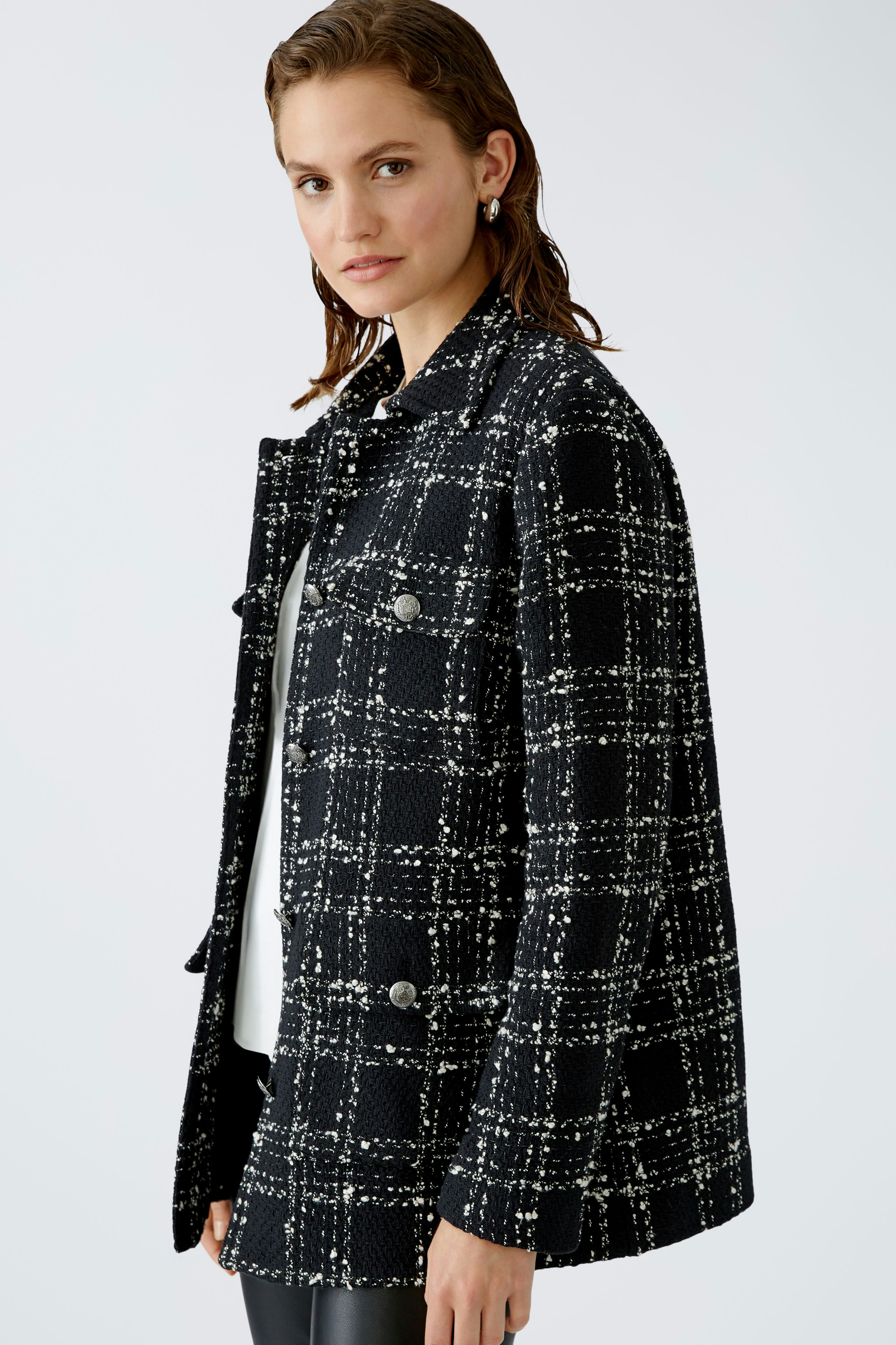 Stylish women's jacket: A woman in a black and white checked jacket exudes elegance and confidence.