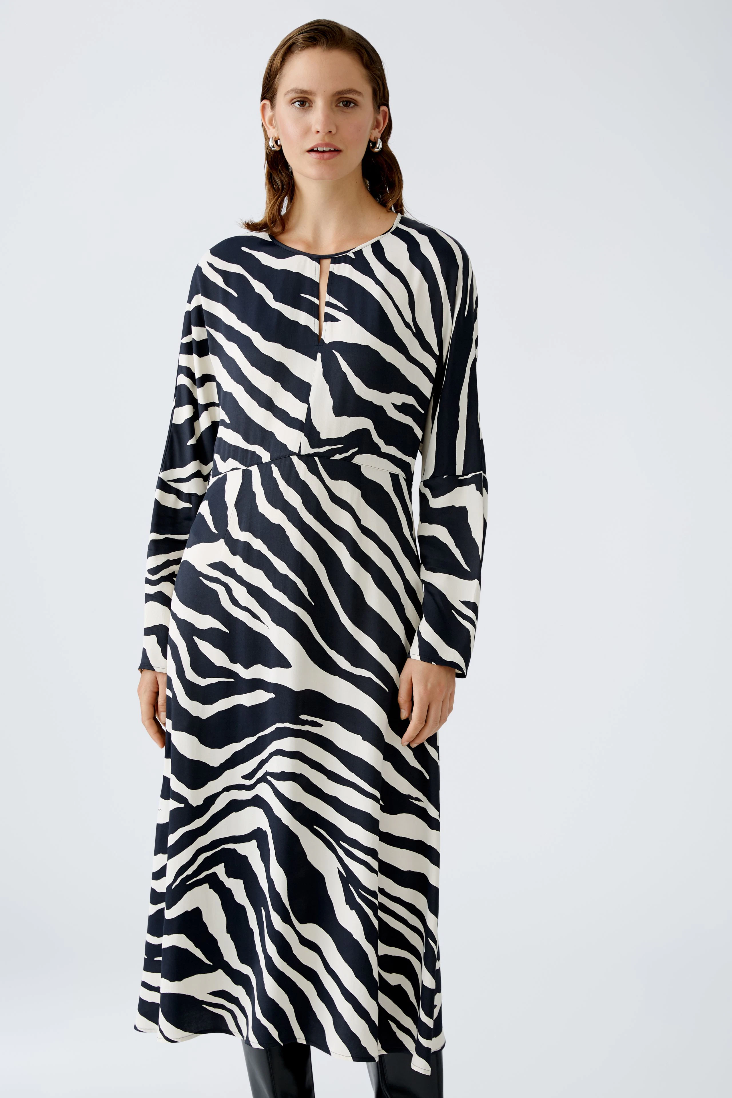 Elegantes Midikleid: Frau in einem gestreiften Kleid mit langen Ärmeln und schickem Ausschnitt.