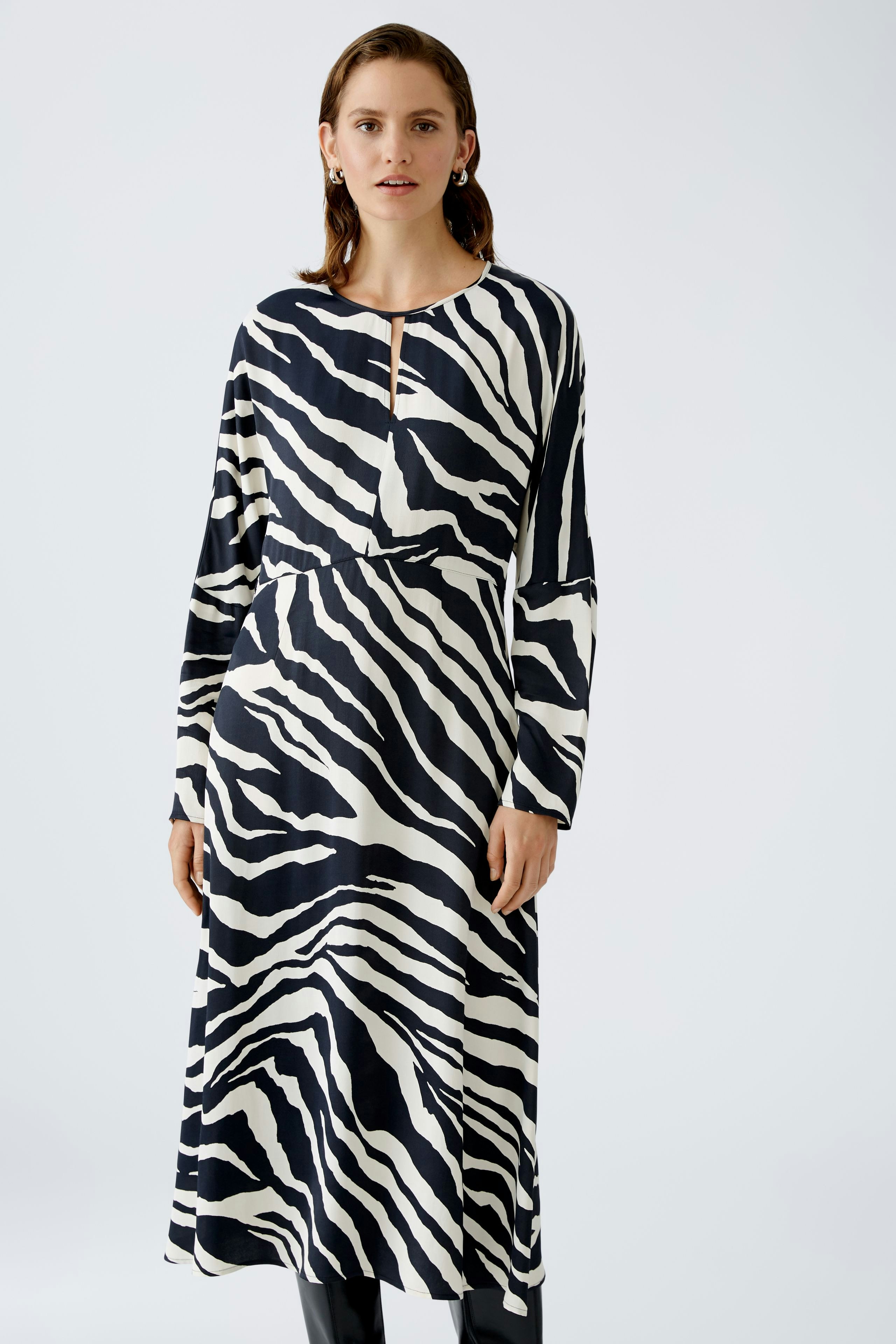 Stylish midi dress: A woman in a black and white zebra print dress with a keyhole neckline.
