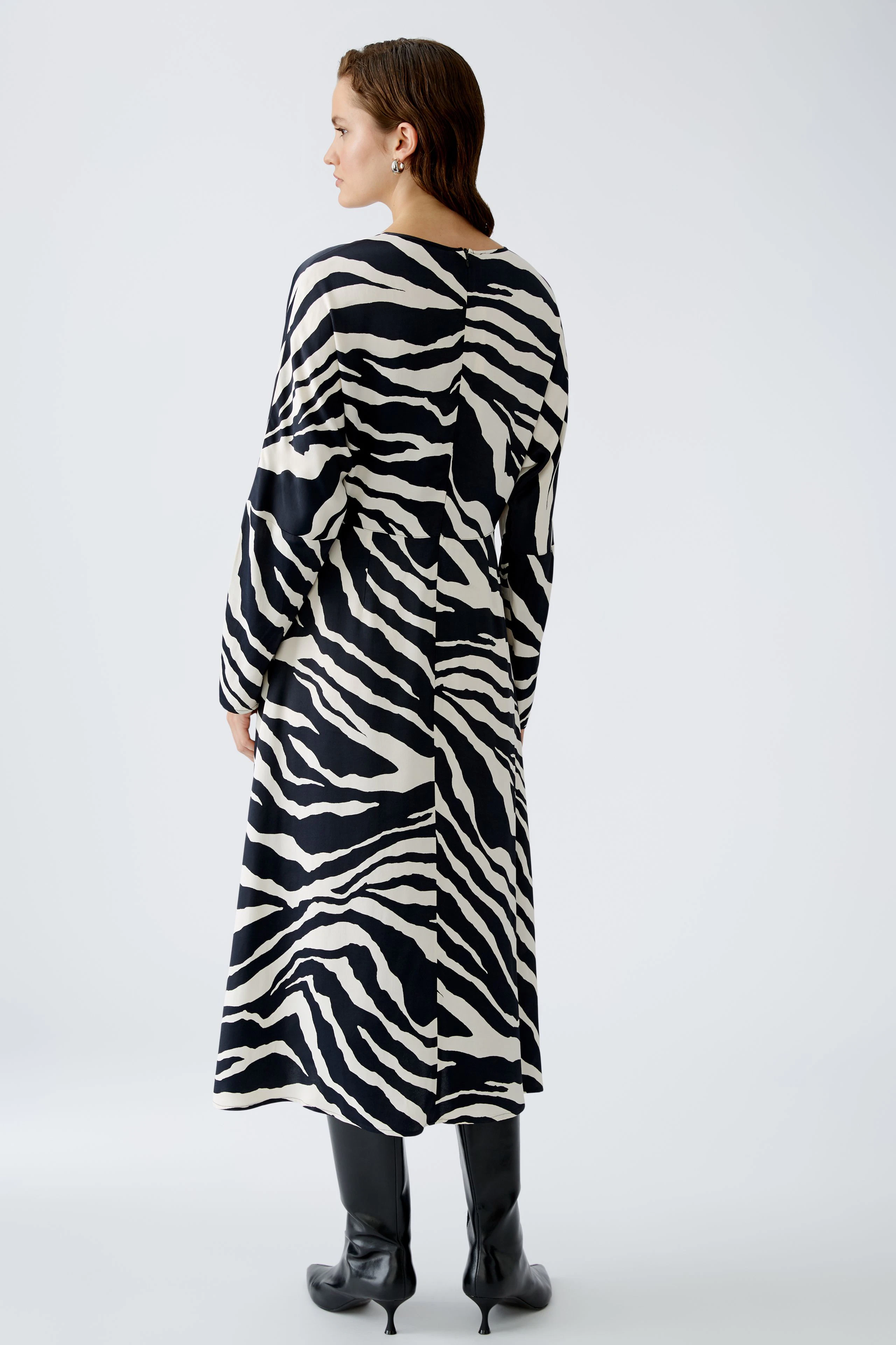 Elegantes Midikleid mit Zebra-Muster: Frau trägt das Kleid mit langen Ärmeln und lässigem Schnitt.