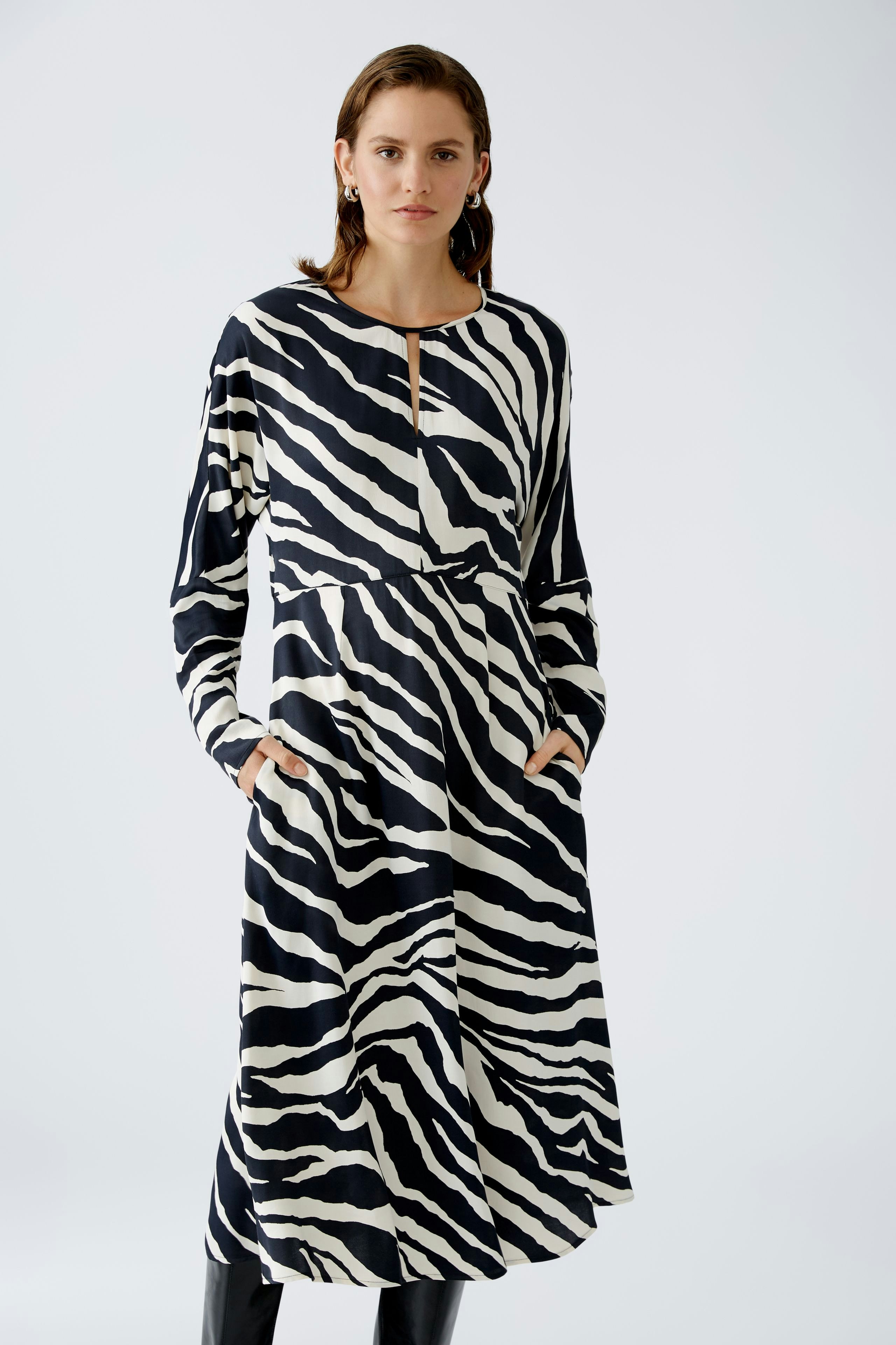 Stylish midi dress: A woman in a black and white zebra-striped midi dress with a flattering silhouette.